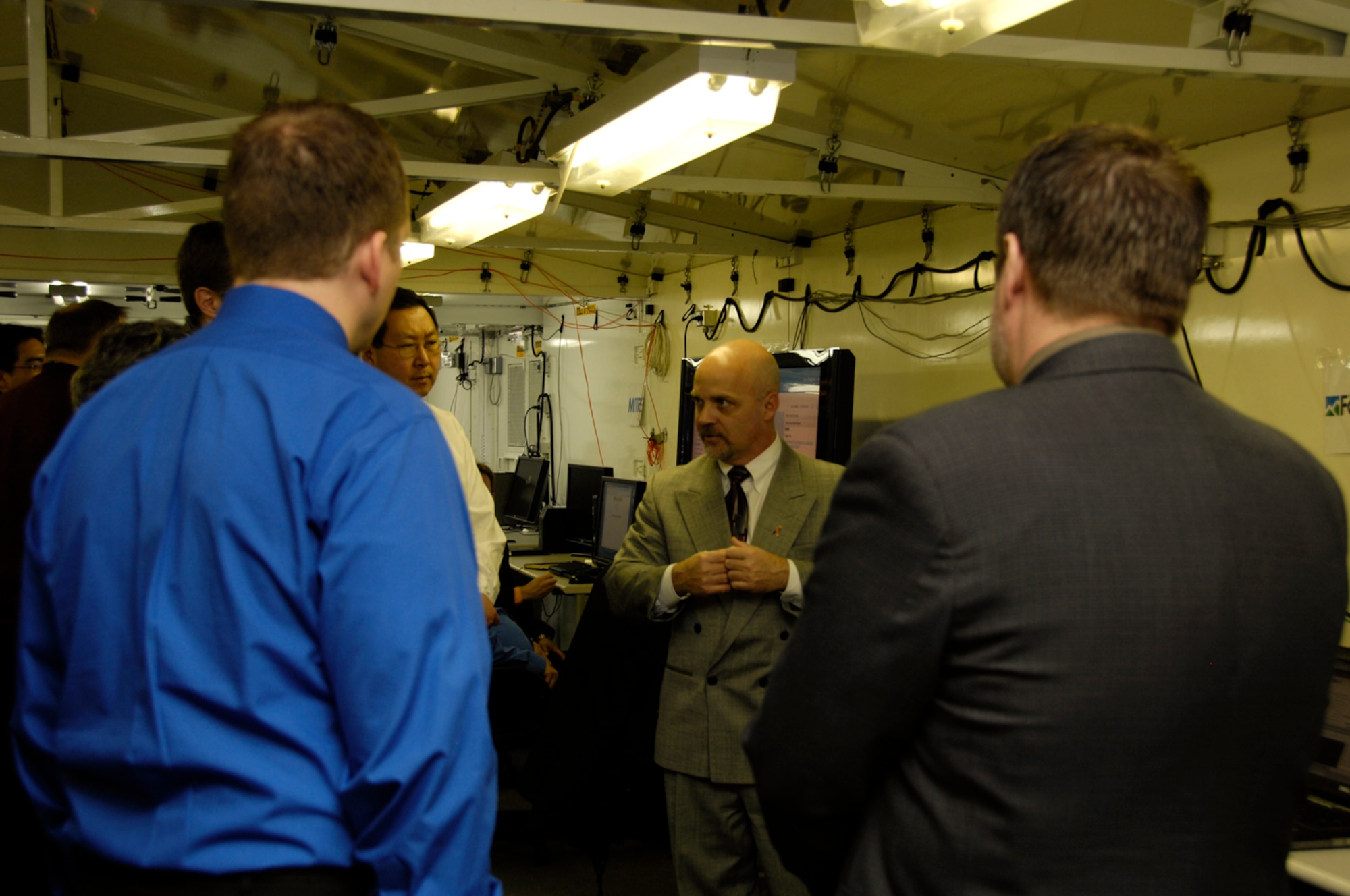 HANSCOM AIR FORCE BASE, Mass. -- Brian Welden of Fenwick Technologies talks with other participants,including Paul Kim of MITRE (facing), during a two-day Technical Exchange Meeting held here Dec. 9 and 10.  The exchange allowed Electronic Systems Center officials and contractor participants to exchange information about and demonstrate six "Net-Centric Path-Finder" technologies.  (US Air Force Photo by Mark Herlihy)
