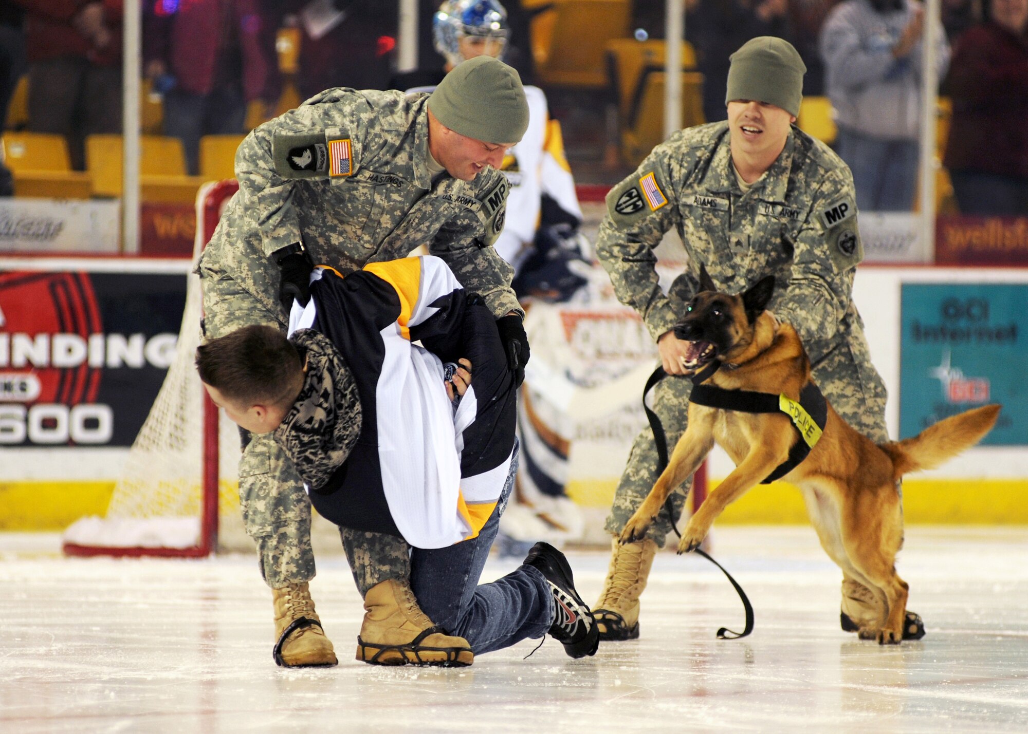 ANCHORAGE, Alaska -- Military police and a military working dog take a person hostage that "stole" the ceremonial puck Dec. 11. The Alaska Aces organization held a three-game military appreciation series Dec. 11-13. (U.S. Air Force photo/Senior Airman Laura Turner)