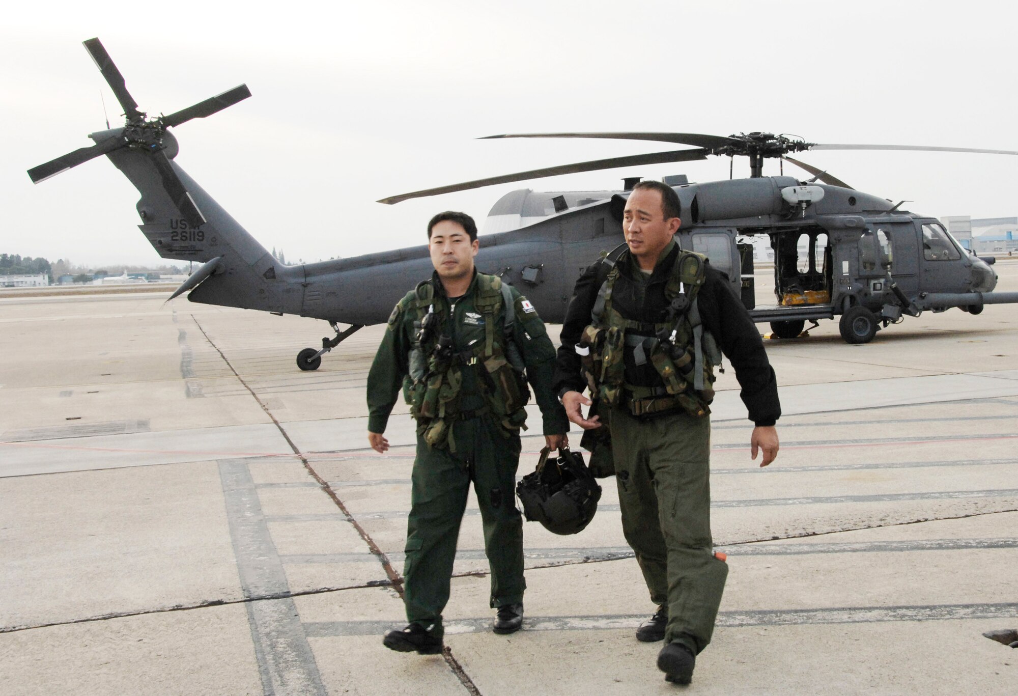 Maj. George Dona (right) and Capt. Takeshi Tokuda head back to an operations building after a day of air refueling training Dec. 9, 2009, at Moffett Federal Airfield, Calif. Major Dona is an HH-60G Pave Hawk helicopter pilot with the 129th Rescue Squadron at Moffett Field. Captain Tokuda is a Japan Air Self-Defense Force UH-60J pilot with the Air Rescue Wing at Komaki Air Base, Japan. (U.S. Air Force photo/Tech. Sgt. Ray Aquino) 
