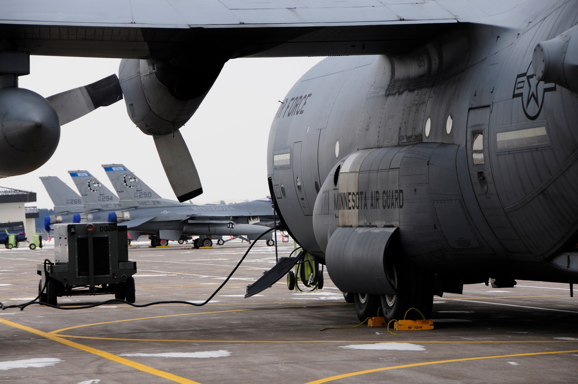 A St. Paul based C-130 Hercules from the 133rd Air Wing awaits the arrival of members of the 148th Fighter Wing Air National Guard as they prepare to depart Duluth, Minn. Dec. 17th, 2009.  A large number of 148th Civil Engineers will deploy to Bagram Airfield, Afghanistan for approximately six months in late 2009 and early 2010.