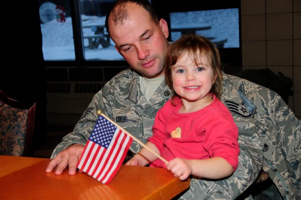 U.S. Air Force Staff Sgt. Mike Cole holds his daughter before saying goodbye as the first wave of Civil Engineers from the 148th Fighter Wing departs Duluth, Minn. Dec. 17th, 2009.  A large number of 148th Civil Engineers will deploy to Bagram Airfield, Afghanistan for approximately six months in late 2009 and early 2010.