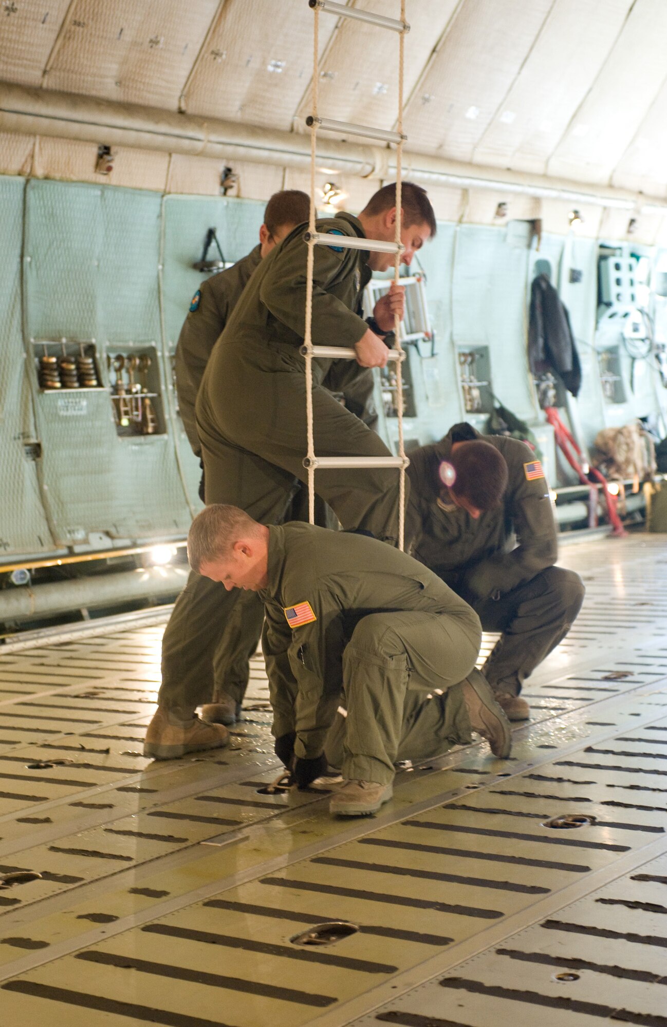 Members of the 9th Airlift Squadron secure a fire escape ladder during a training exercise Dec. 1. The 9th AS stresses safety as the most important aspect of any exercise, training or real world mission. (U.S. Air Force photo/Brianne Zimny) 