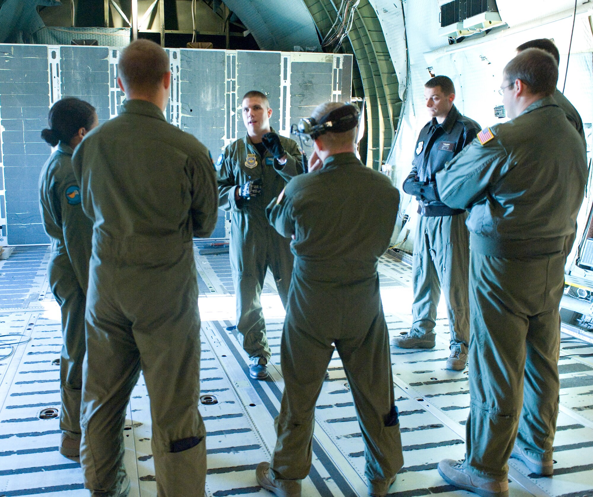 Members of the 9th Airlift Squadron gather for a pre-training briefing Dec. 1. The 9th AS flies C-5 Galaxy aircraft to deliver personnel and cargo in support of American interests around the globe. (U.S. Air Force photo/Brianne Zimny) 