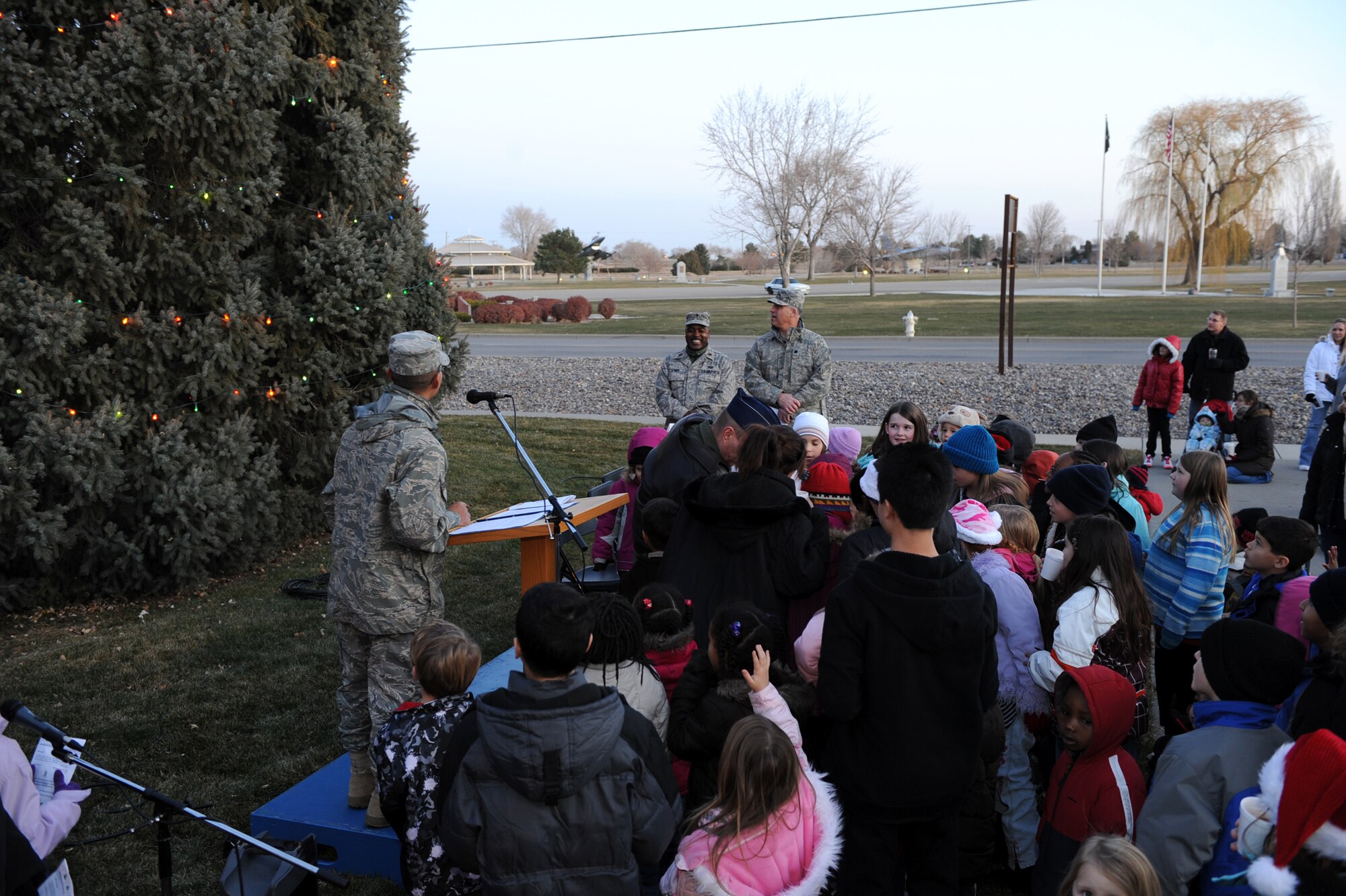 MOUNTAIN HOME AIR FORCE BASE, Idaho -- Spectators watch as the tree lights up during the annual Christmas tree lighting ceremony at the base chapel Dec. 4. The 366th Fighter Wing chapel office and the First Sergeants association teamed up to put together a holiday parade followed by the tree lighting ceremony. (U.S. Air Force photo by Master Sgt. Tim Cook)
