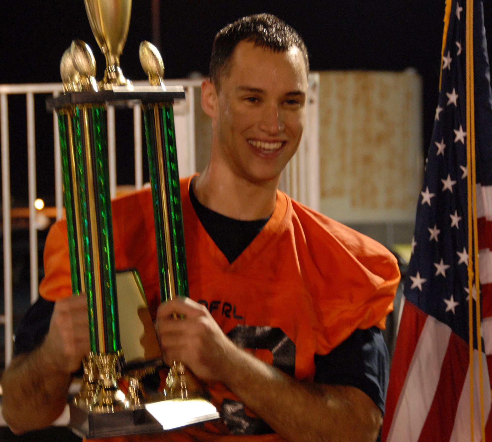 Tim Ager, Air Force Research Lab wide receiver holds up the base championship trophy Dec. 16 after his team defeated the 53rd Wing 26-6.  Ager contributed two touchdowns and an extra point in the effort.  AFRL controlled the game with sharp passing and a frustrating blitz defense.  The AFRL team only had one loss all season.  (Air Force photo/Samuel King Jr.)