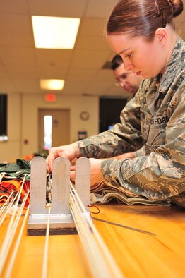 Airman 1st Class Emily Bertini, 4th Operations Support Squadron life support journeyman, airs a parachute canopy on Seymour Johnson Air Force Base, N.C., Dec. 15, 2009. Airing is the process of smoothing the canopy so it can be packed properly. Airman Bertini is originally from Springtown, Texas. (U.S. Air Force photo/Airman 1st Class Rae Perry)