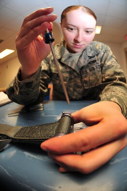 Airman 1st Class Emily Bertini, 4th Operations Support Squadron life support journeyman, opens a parachute's underwater activation release system on Seymour Johnson Air Force Base, N.C., Dec. 15, 2009. The UWARS attaches to the harness worn by aircrew members and will disconnect the parachute in the event of a water landing. Airman Bertini is originally from Springtown, Texas. (U.S. Air Force photo/Airman 1st Class Rae Perry)