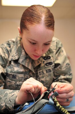 Airman 1st Class Emily Bertini, 4th Operations Support Squadron life support journeyman, replaces tackings on a parachute's riser on Seymour Johnson Air Force Base, N.C., Dec. 15, 2009. Tackings keep parachute rigging parts in place so they do not come apart. Airman Bertini hails from Springtown, Texas. (U.S. Air Force photo/Airman 1st Class Rae Perry)