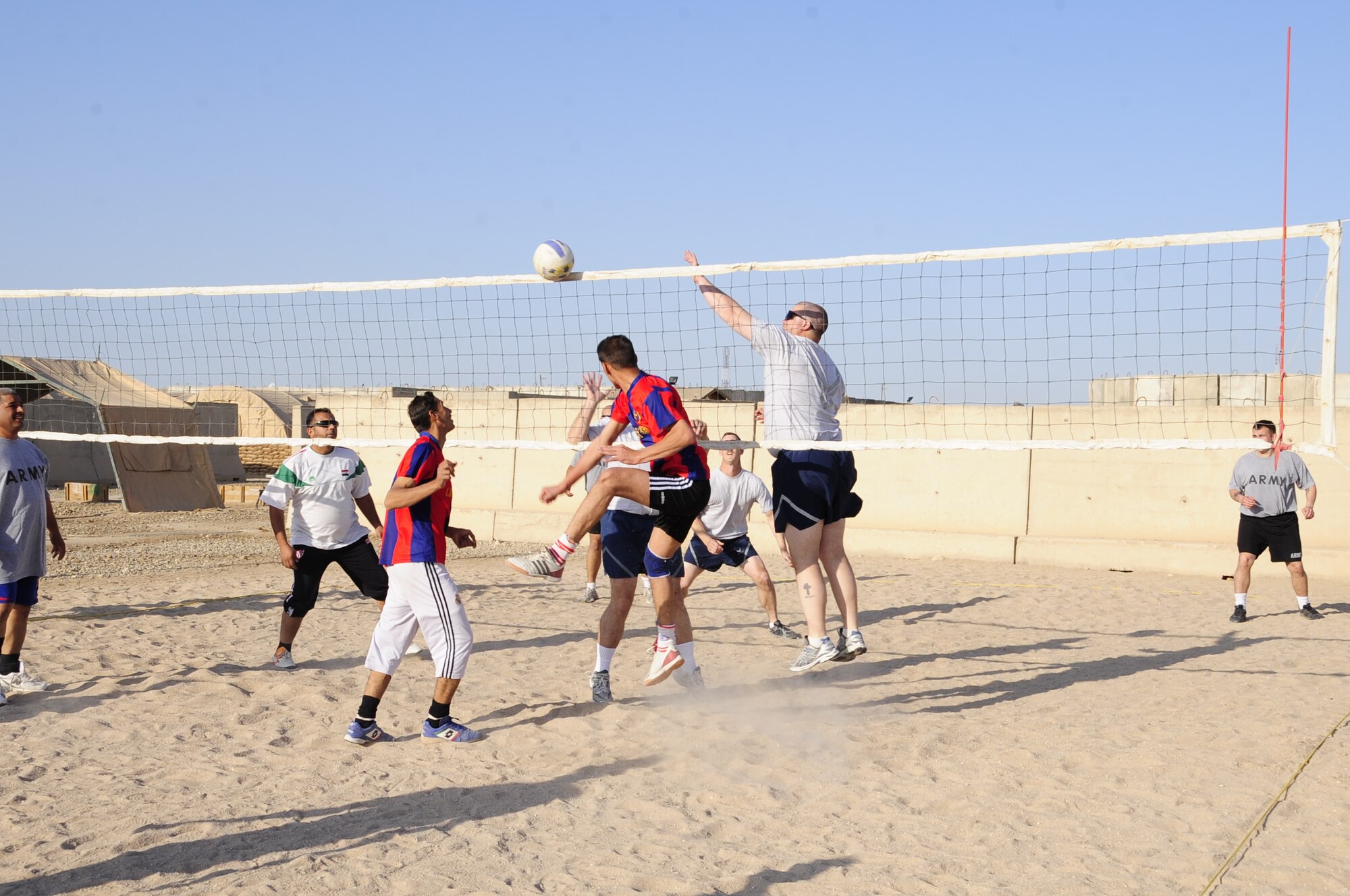Ali Base, Iraq - Airmen and Soldiers assigned to the Tallil Logistics Military Advisory Team host Iraqi soldiers for a friendly game of volleyball here Dec. 16, 2009.  The LMAT is one of nine teams assisting the Iraqi Army in their efforts to assume independent operations.  The LMAT hosted the event to continue to build trust and rapport with their Iraqi counterparts. (U.S. Air Force photo/Master Sgt. Darrell Habisch)  