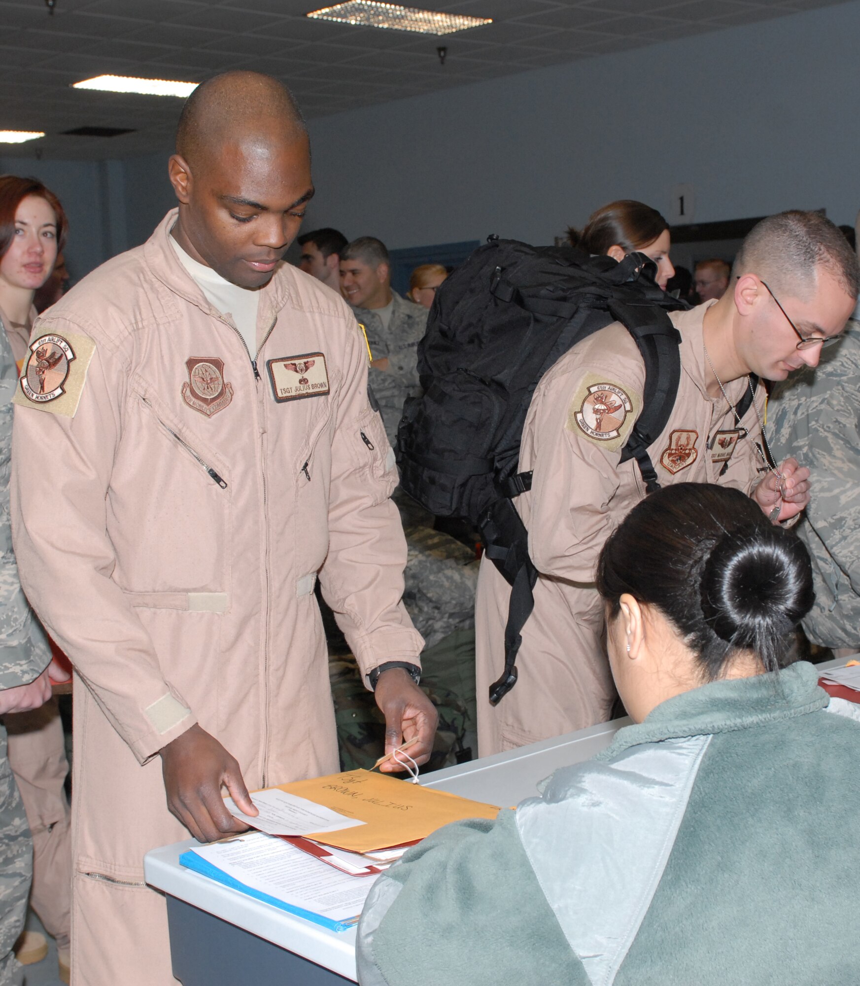 Tech. Sgt. Julius Brown, 61st Airlift Squadron loadmaster, goes through a deployment process line Dec. 9 as members of the 61st AS prepare for deployment at the base’s passenger terminal. The 61st AS Airmen deployed to Balad Air Base, Iraq, supporting Operation Iraqi Freedom. (U.S. Air Force photo by Senior Airman Christine Clark)