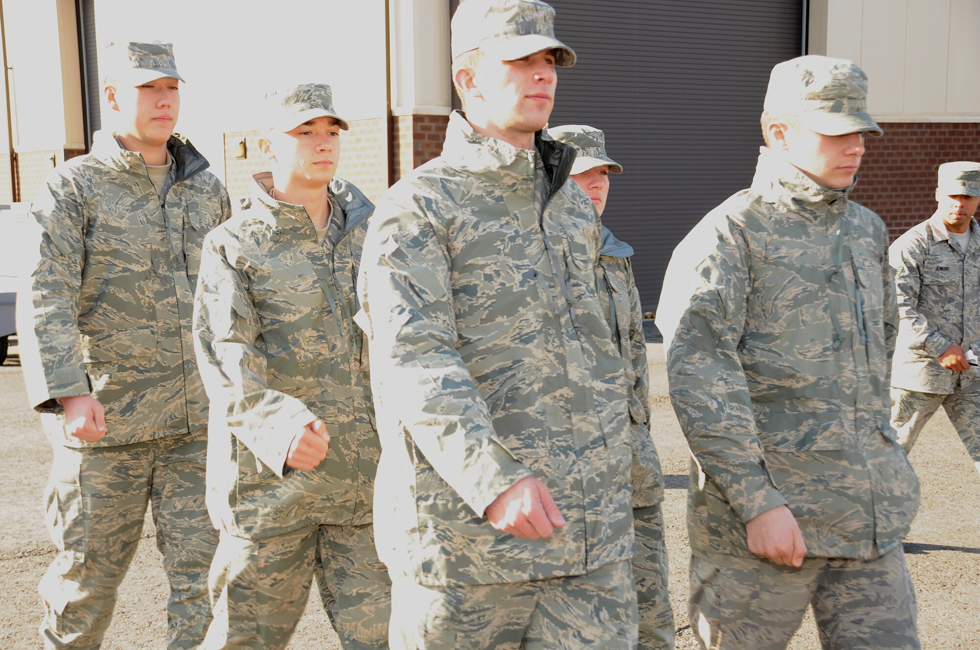 A formation of Airmen attending the KC-10 Extender crew chief technical school here march to the chow hall after classes. Staff Sgt. Andre Jenkins, the group's Military Training Leader, watches them from the side. The KC-10 crew chief school officially stood up in 1998 as a 5-skill level training course. But this year, JB MDL saw its first year of phase-three trainees. These brand-new Airmen arrived on McGuire as a follow-on to a six-week initial training course at Sheppard Air Force Base, Texas. (U.S. Air Force photo/Pascual Flores). 
