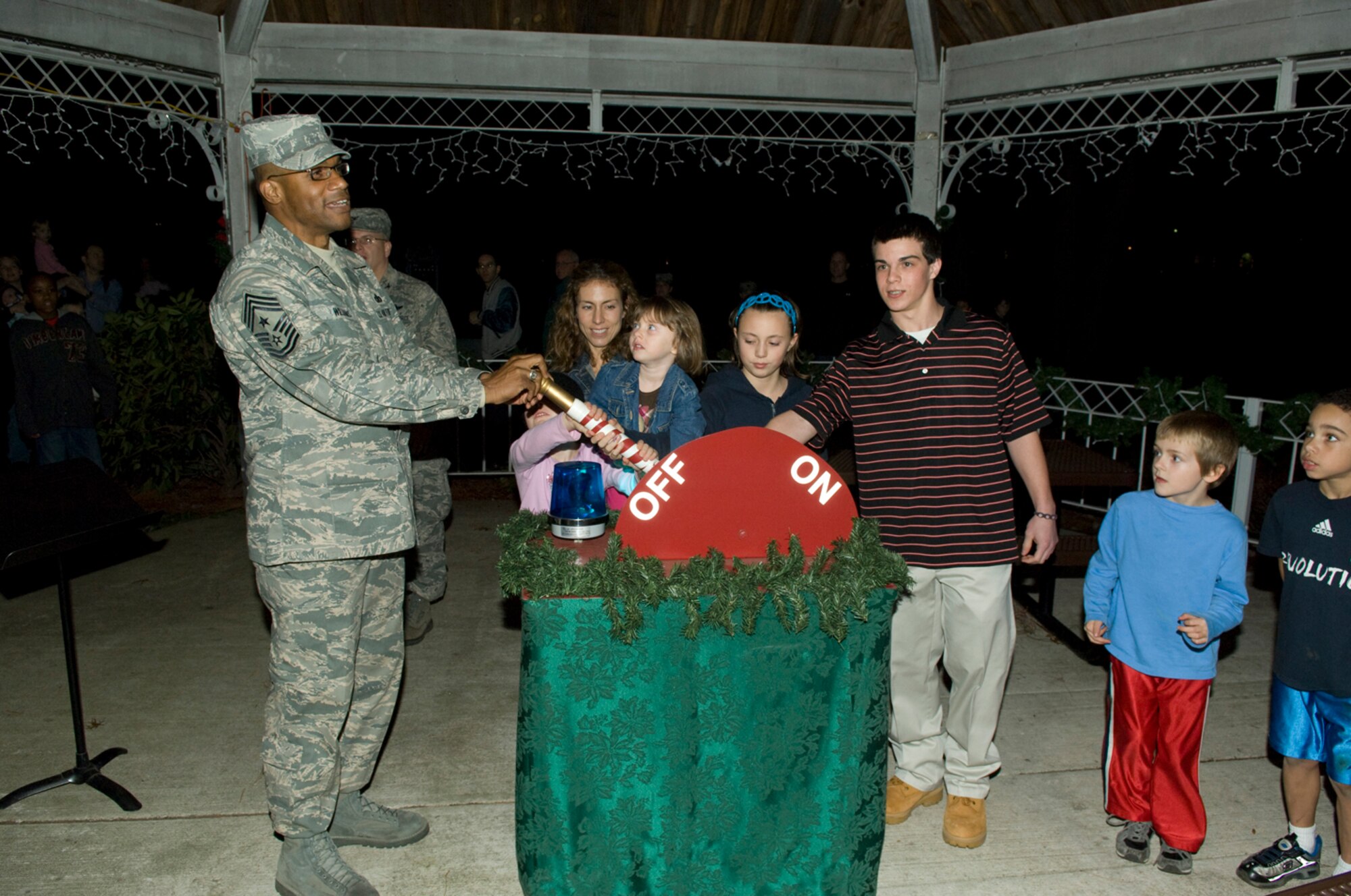 HANSCOM AIR FORCE BASE, Mass. -- Chief Master Sgt. Kenneth Williams, Electronic Systems Center and 66th Air Base Wing command chief, helps children of deployed Hanscom Airmen and Andrew Matos, a winner of the Boys and Girls Club of America's Youth of the Year award, flip the switch for the tree-lighting ceremony Dec. 4.  (U.S. Air Force photo by Rick Berry) 