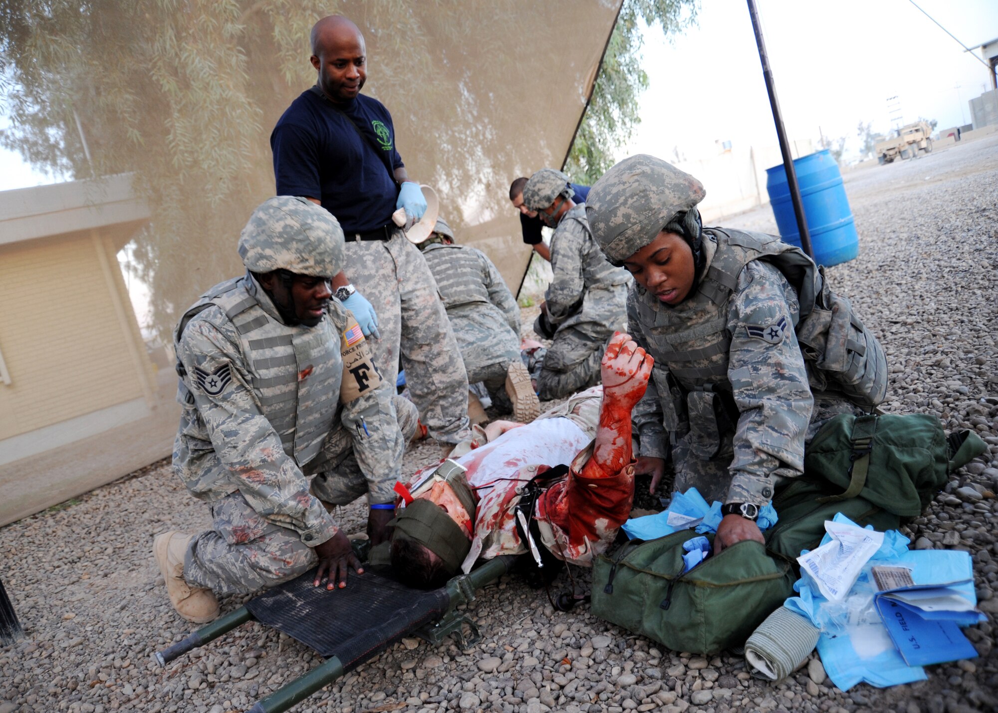 JOINT BASE BALAD, Iraq -- Army Sgt. Roger Farlow of the 1st Medical Brigade evaluates Air Force Staff Sgt. Robert Charles, 332nd Expeditionary Civil Engineer Squadron force protection escort, and Airman 1st Class Acquah Hill of the 532nd Expeditionary Security Forces Squadron, as they provide simulated care under fire during a combat lifesaver course Dec. 11, 2009. The course qualifies servicemembers on tactical life-saving skills. (U.S. Air Force photo/Senior Airman Christopher Hubenthal)
