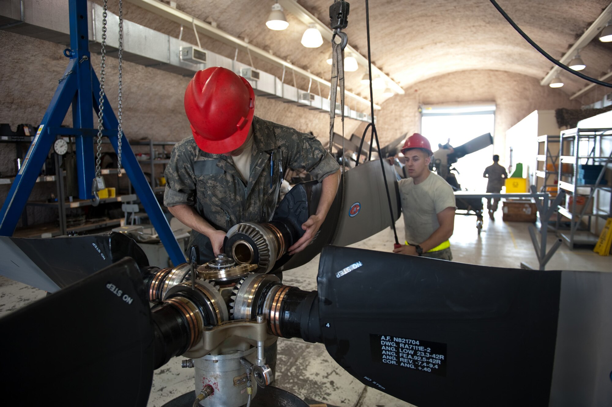 Left,Staff Sgt. Sean Acrea and Airman 1st Class Chirs Basile, 379th Expeditionary Maintenance Squadron, install a new propeller blade into a C-130H Hercules hub assembly, Dec. 15, 2009, in Southwest Asia. Sergeant Acrea and Airman Basile work in a centralized repair facility to refurbish and repair C-130 propeller assemblies for aircraft operating throughout Southwest Asia. (U.S. Air Force photo/Staff Sgt. Robert Barney) 