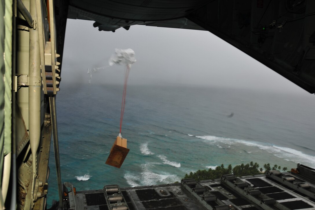 CHUUK, Commonwealth of the Northern Marianas Islands -- A Unicross UNX 150 strapped to a bundle of donated goods opens after dropping out the back of a C-130 Hercules over a Chuuk island during Operation Christmas Drop Dec. 16. Operation Christmas Drop, the longest running humanitarian airlift mission in the world, delivers supplies to remote islands of the Commonwealth of the Northern Marianas Islands of Yap, Palau, Chuuk and Pohnpei. (U.S. Air Force photo/Tech. Sgt. Kimberly Spinner)