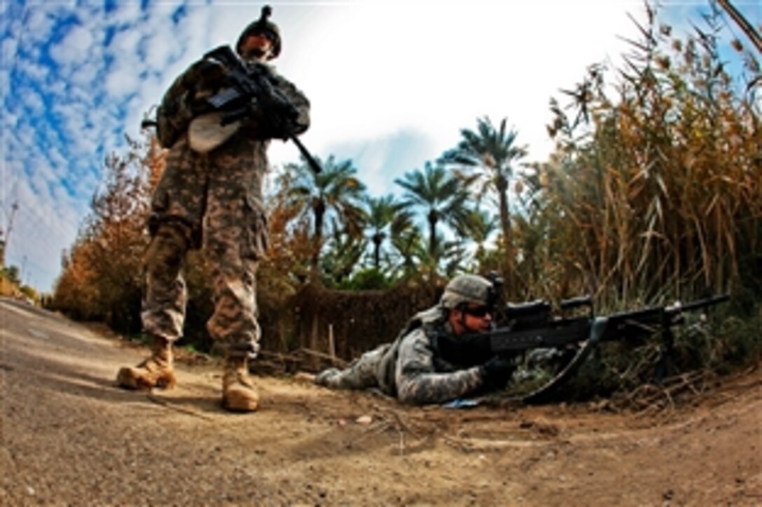 Army Spc. Sean Kuttner, left, and Pfc. John Cummings, right, provide security at a traffic control point, Taji, Iraq, Dec. 12, 2009. 