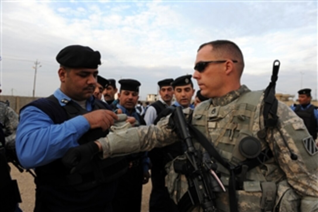 U.S. Army Staff Sgt. Michael Davis, Mortar Platoon, Headquarters and Headquarters Company, 1st Battalion, 30th Infantry Regiment, 2nd Brigade Combat Team, 3rd Infantry Division, allows a member of the Iraqi Emergency Response Unit to practice first aid techniques on his arm during first responder training at the Response Unit’s compound in Kirkuk, Iraq, on Dec. 12, 2009.  The battalion works with the Emergency Response Unit to improve the professionalism and capabilities of Iraqi personnel.  