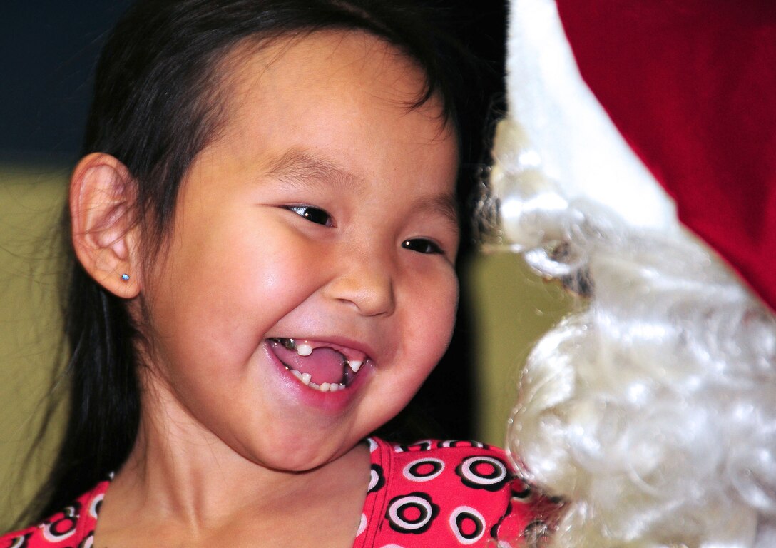 Hope Campbell, age 3, lights up the Gambell Public School gymnasium as she visits with Santa on Dec. 16, 2009. The Alaska Air and Army National Guard were in Gambell, on remote St. Lawrence Island in the Bering Sea, with a group of civilian volunteers as part of Operation Santa Claus. Now in its 53rd year, Operation Santa Claus is a program of the Alaska National Guard to bring toys, food, supplies and Christmas cheer to isolated villages around the state. Alaska Air National Guard photo by 1st. Lt. John Callahan.