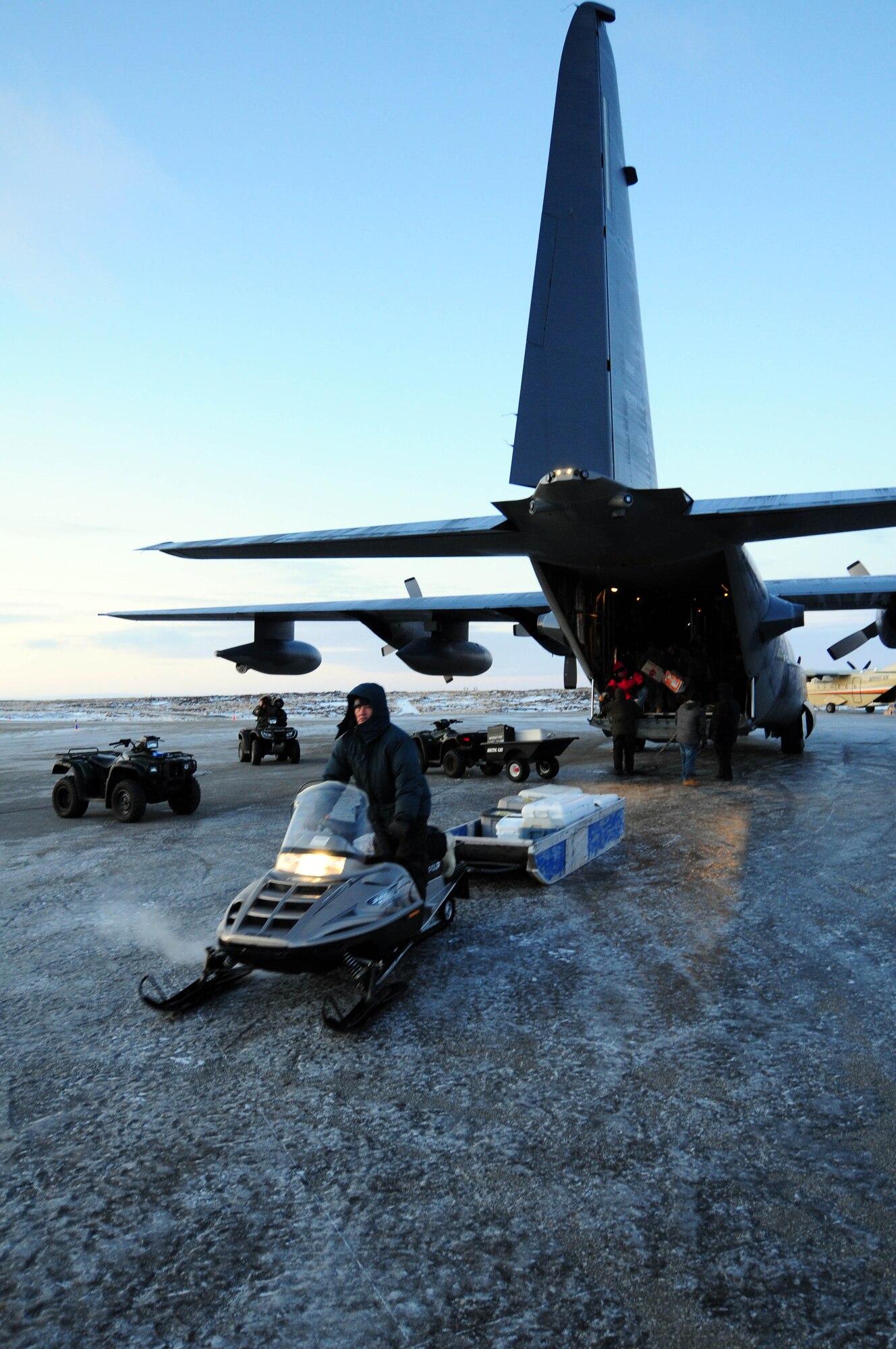 Gambell resident Merle Kaningok, an employee of the Gambell Public School,
hauls a load of toys and Christmas goodies away from an Alaska Air National Guard HC-130 transport aircraft. The Alaska Air and Army National Guard were in Gambell, on remote St. Lawrence Island in the Bering Sea, with a group of civilian volunteers as part of Operation Santa Claus 2009. Now in its 53rd year, Operation Santa Claus is a program of the Alaska National Guard to bring toys, food, supplies and Christmas cheer to isolated villages around the state. Alaska Air National Guard photo by 1st. Lt. John Callahan.