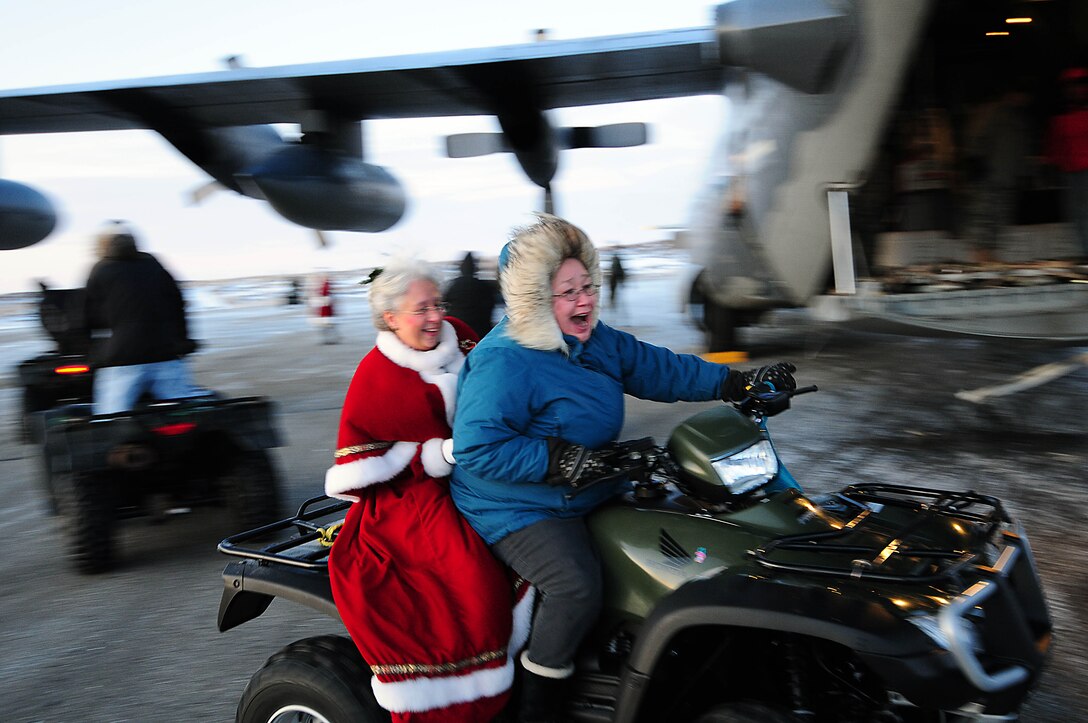 Gambell resident Betsy Katongan whisks Mrs. Santa by an Alaska Air National Guard HC-130 transport aircraft on their way to the Gambell Public School. The Alaska Air and Army National Guard were in Gambell, on remote St. Lawrence Island in the Bering Sea, with a group of civilian volunteers as part of Operation Santa Claus 2009. Now in its 53rd year, Operation Santa Claus is a program of the Alaska National Guard to bring toys, food, supplies and Christmas cheer to isolated villages around the state. Alaska Air National Guard photo by 1st. Lt. John Callahan.