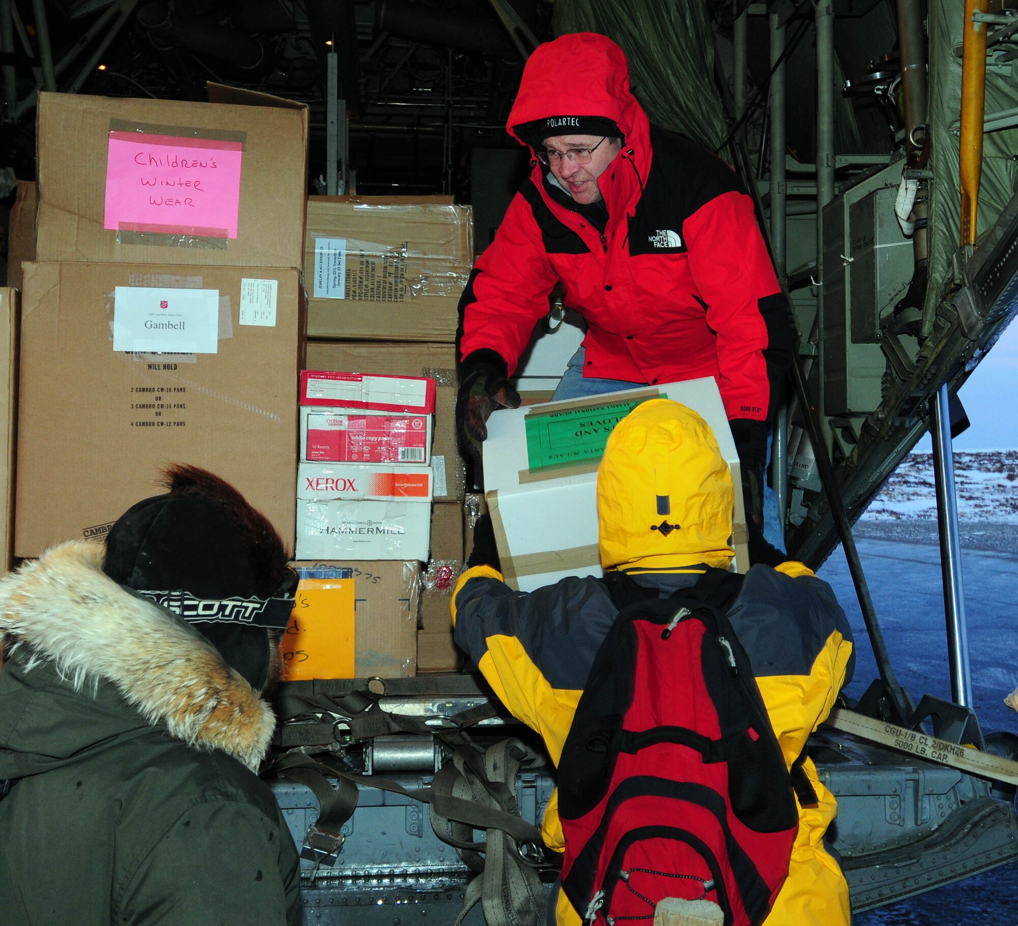 Rich Owens, owner of the Alaska Tastee-Freez restaurant in Anchorage and a long-time supporter of military programs in Alaska, helps offload a 176th Wing HC-130 in the village of Gambell on Dec. 16, 2009. The Alaska Air and Army National Guard were there as part of Operation Santa Claus 2009. Operation Santa Claus is a 53-year program of the Alaska National Guard to bring toys, food, supplies and Christmas cheer to isolated villages around the state. Alaska Air National Guard photo by 1st. Lt. John Callahan.