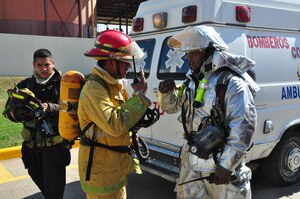 Staff Sgt. Brandon Johnson and a Honduran firefighter from the Comayagua fire department assess the situation during an industrial fire exercise between U.S. and Honduran firefighters designed to increase their capabilities in working together. Sergeant Johnson is assigned to the 612th Air Base Squadron fire department at Soto Cano Air Base, Honduras. (U.S. Air Force photo/Tech. Sgt. Mike Hammond)