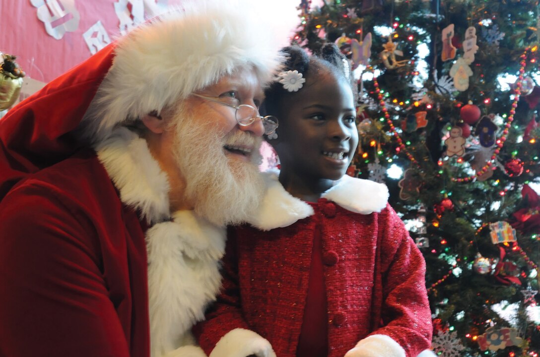 Ania Timmons, 4, looks to her mother, Nellie Pope-Weaver, 779th Medical Group physical evaluation board liaison, as she has her photo taken with Santa Claus at the Breakfast With Santa event held at the Youth Center Saturday. Joint Team Andrews children told Santa what they wanted for Christmas and received their own gift of a doll or race car. More than 360 people attended the event, which included breakfast with Santa and various holiday dance presentations by Team Andrews youth. The Andrews Youth Center hosts various activities for children throughout the year, including holiday, sports and educational events. (U.S. Air Force photo/ Airman 1st Class Kat Lynn Justen)