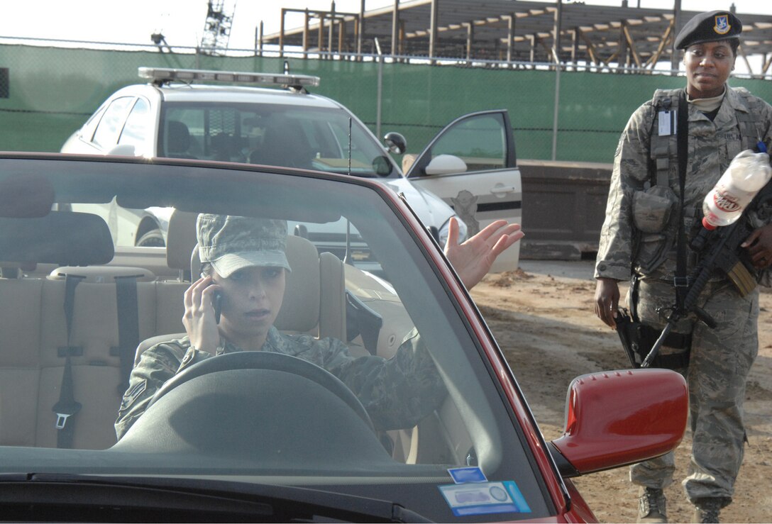 Technical Sgt. LaShondra Palmer, 316th Security Forces Squadron patrolman, right, approaches a driver during a simulated traffic stop Dec. 14. The simulated infractions include many unsafe and illegal actions such as speeding, talking on the phone while driving on base, littering and not wearing a seat belt. All drivers on Andrews must be part of the solution; remain safe and obey traffic laws while driving, display their pride in the installation and show their respect for others by not littering. (U.S. Air Force photo/ Staff Sgt. Christopher Marasky)