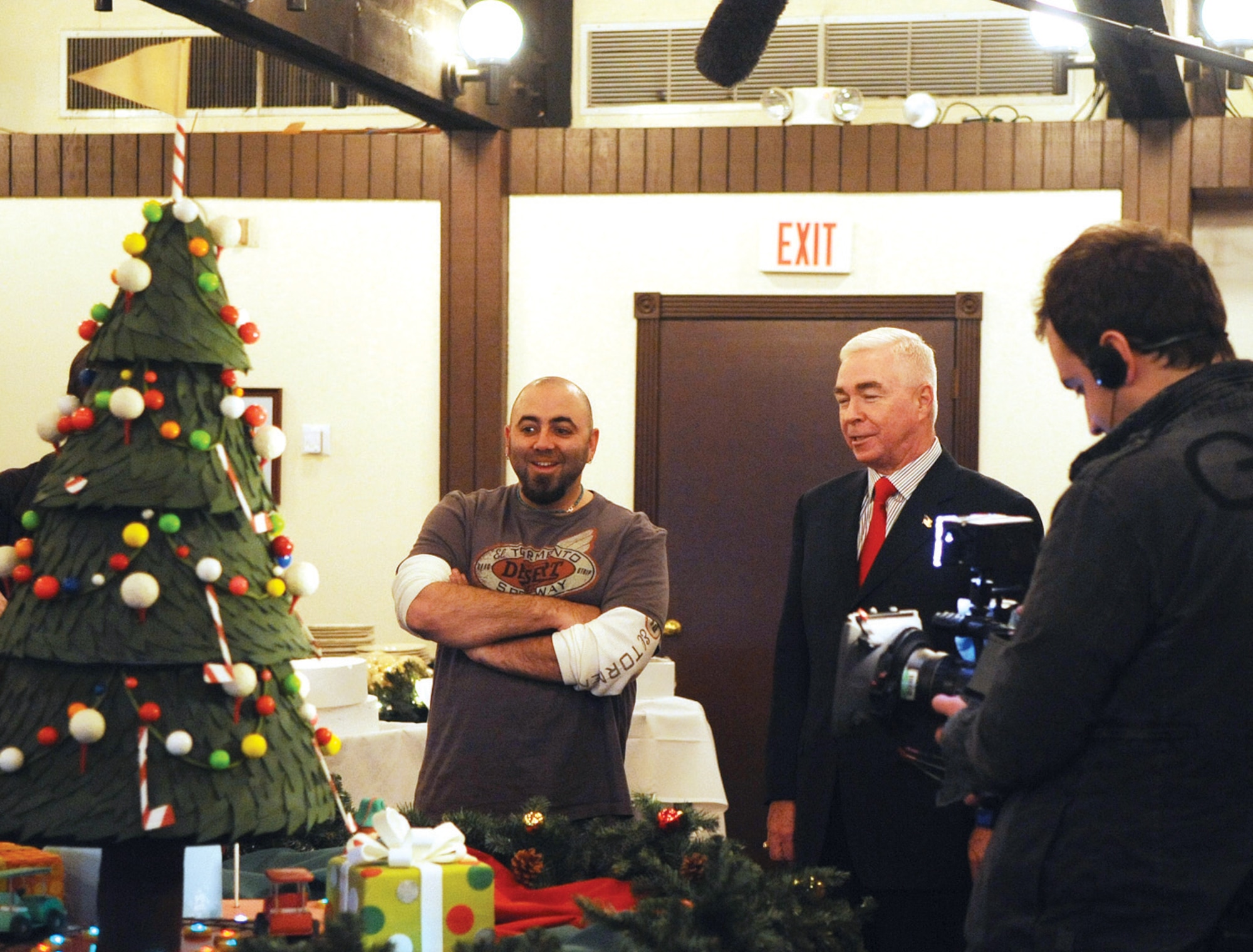 Duff Goldman, owner of Charm City Cakes in Baltimore and star of ‘Ace of Cakes’ on the Food Network, left, presents a golf themed Christmas tree cake to Michael Thomas, The Courses at Andrews general manager, at Joint Base Andrews Dec. 8. The cake was ordered by Ron Johnston, assistant general manger of the golf course for their annual holiday open house for members of the club and distinguished guests. The cake took approximately an hour to put together and its construction was filmed for the television show to air in 2010. (U.S. Air Force photo/ Airman 1st Class Melissa Rodrigues)
