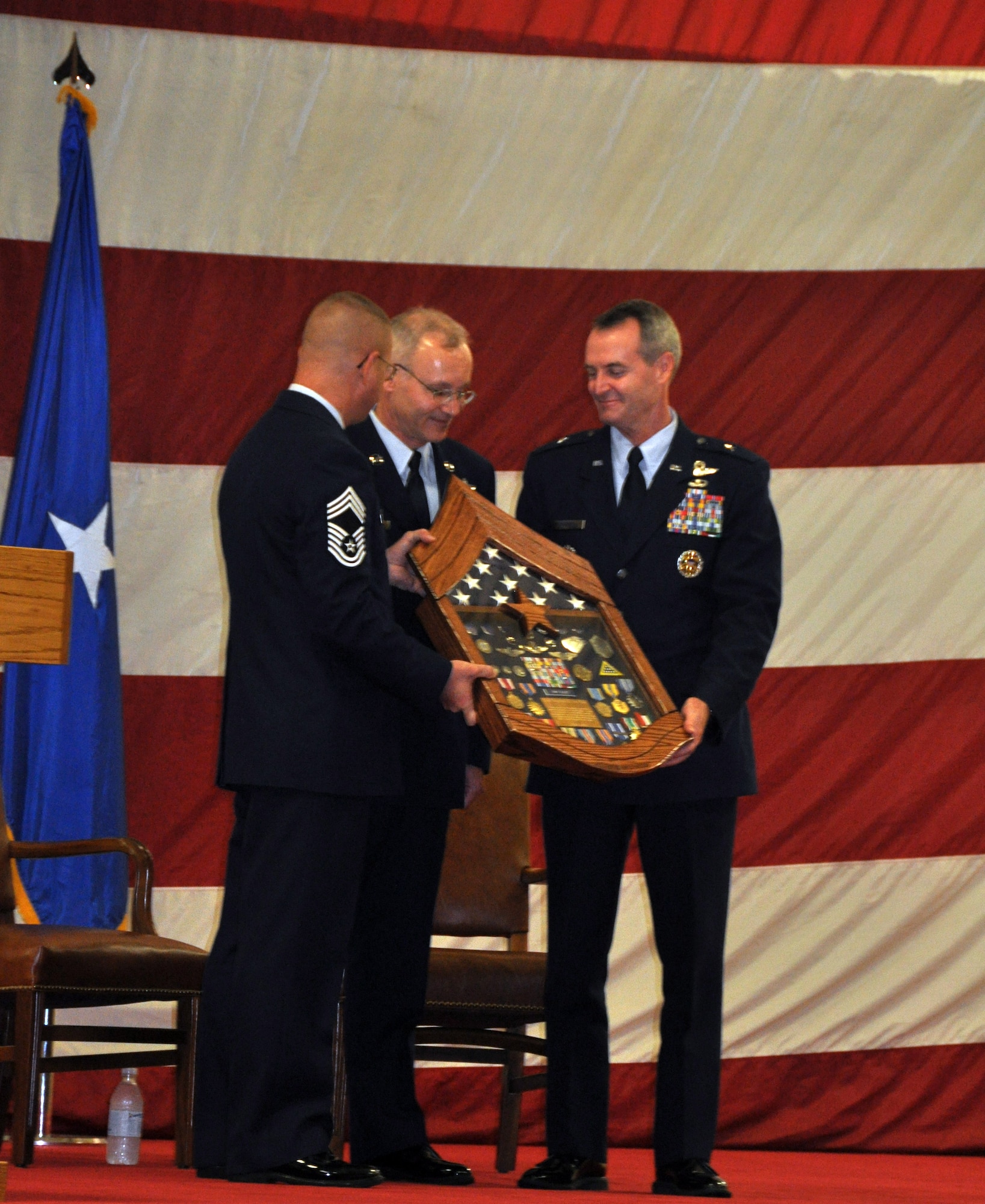 Chief Master Sgt. Michael Goetz, 325th Mission Support Group Superintendant, and General Roberson, 325th Fighter Wing Commander present Chief Master Sgt. Benjamin Van Vleet, 325th Fighter Wing Command Chief, with a shadow box Dec. 18 during his retirement ceremony. After more than 30 years of service, Chief will retire to his home state, Oregon. (U.S. Air Force photo by Airman 1st Class Rachelle Elsea)