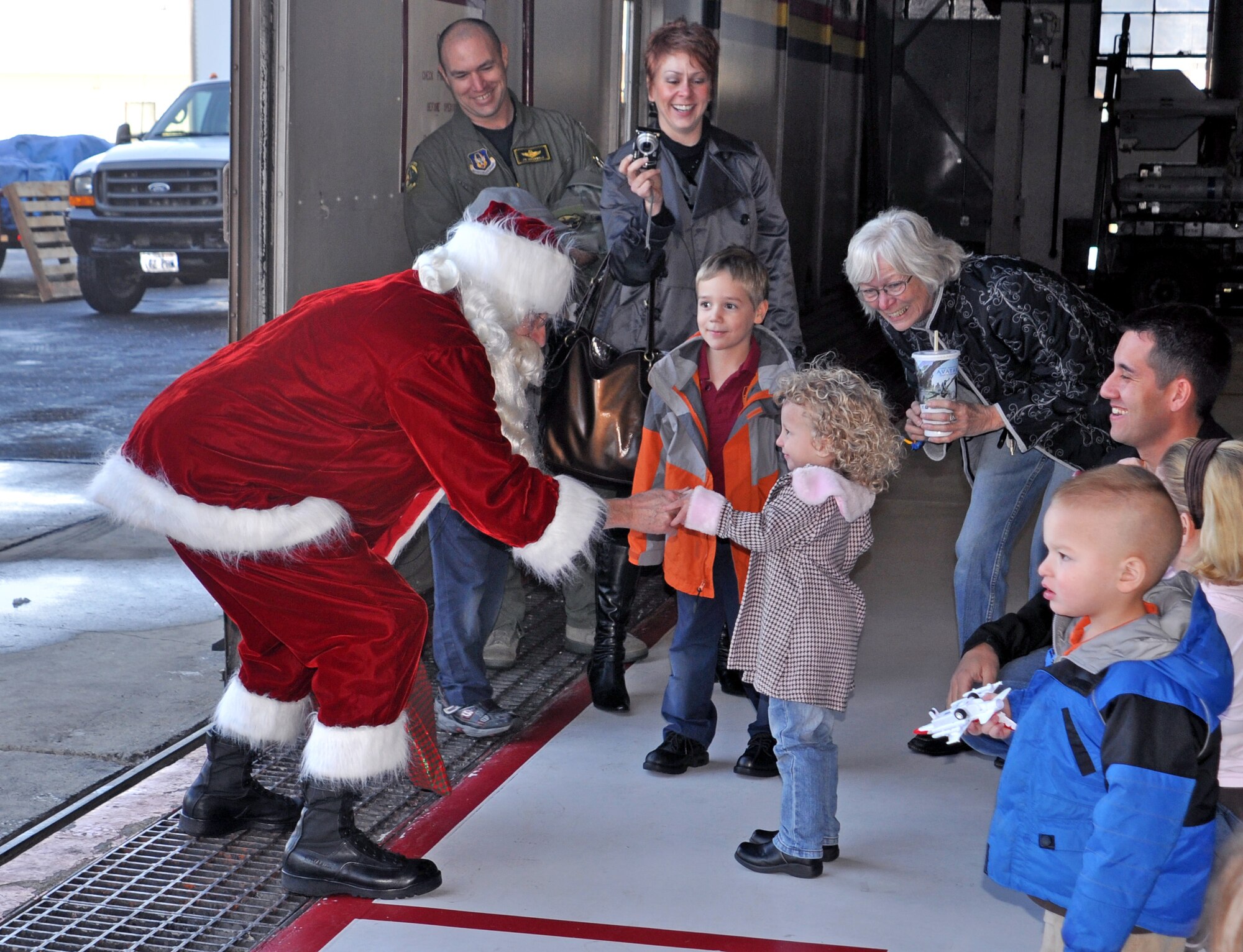 Santa, played by 419th Fighter Wing Commander Col. Walter “Buck” Sams, greets Lorelei Richins, daughter of Master Sgt. Phillip Richins, of the 419th Aircraft Maintenance Squadron. Santa arrived at the wing’s annual Christmas party in an F-16 Dec. 17. (U.S. Air Force photo/Bryan Magaña)