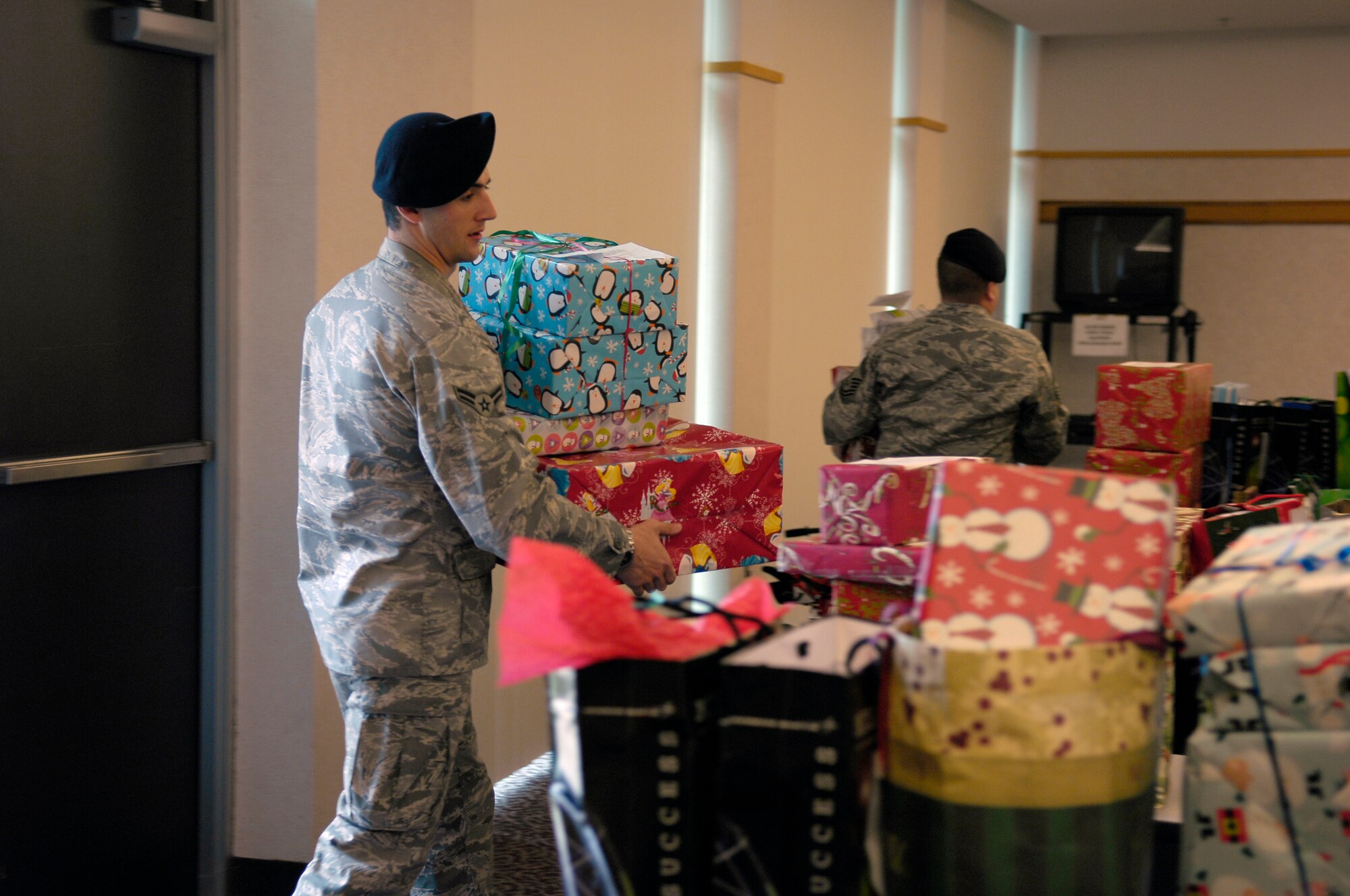 Airman 1st Class Robert Gay, 43rd Security Forces Squadron, carries presents into the main building for the Cumberland County Department of Social Services Dec. 14. (U.S. Air Force photo/Senior Airman Kris Levasseur)