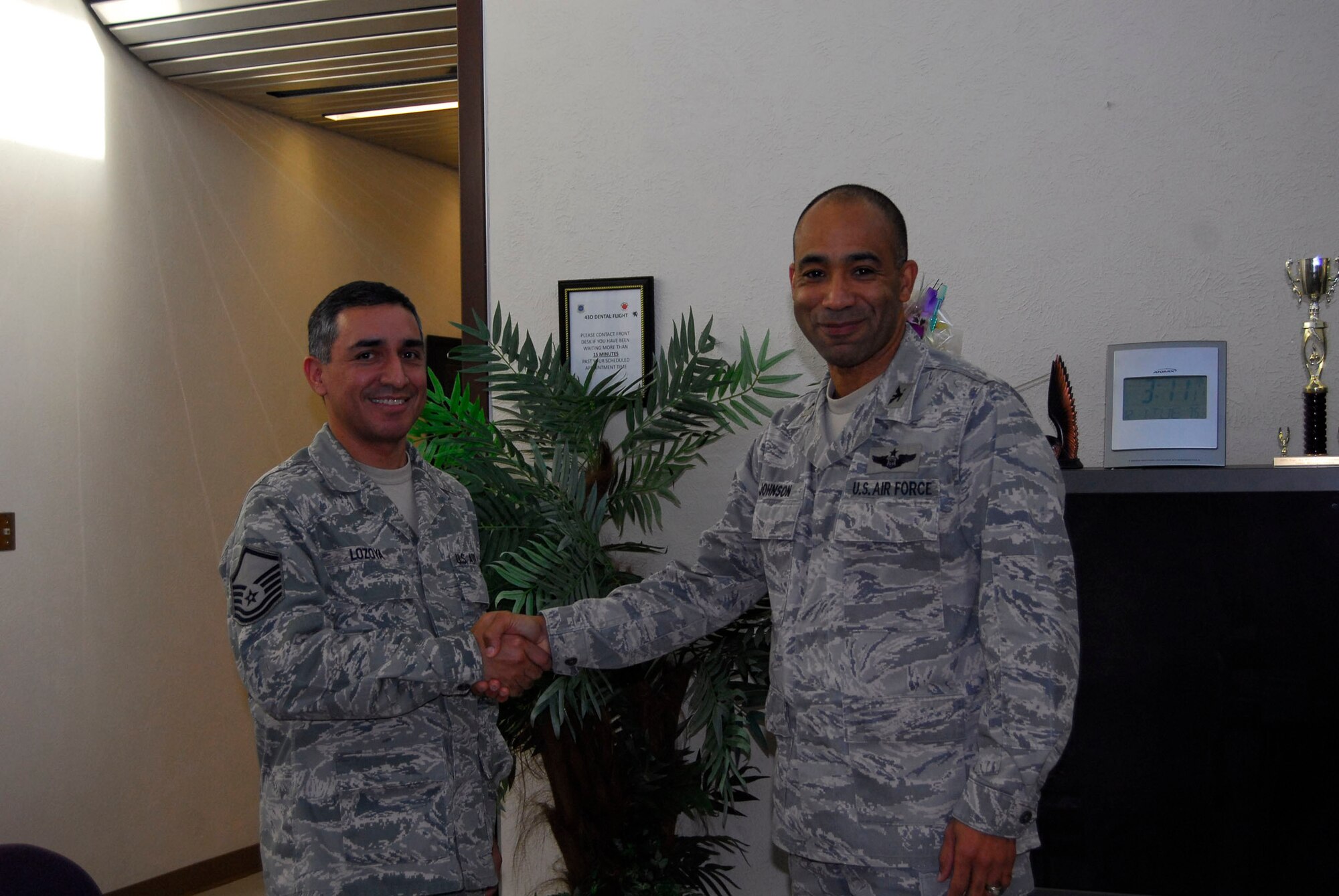 Col. James Johnson, 43rd Airlift Wing Commander, presents Master 
Sgt. Peter Lozoya, 43rd Aerospace Medical Squadron, a Commander’s Coin 
in the Pope Dental Clinic.History Corner 

