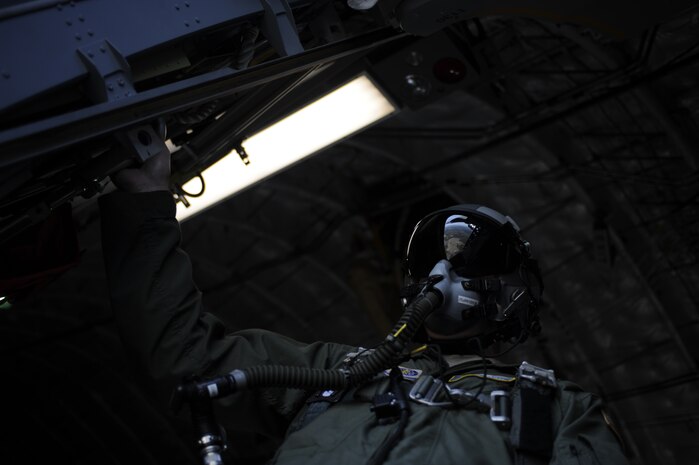 U.S. Air Force Staff Sgt. William Elliot, a loadmaster with the 14th Airlift Squadron, looks out the paratroop door prior to releasing equipment over North Auxiliary Airfield near North, S.C. on Dec. 16 ,2009.  Charleston Air Force Base Airmen conducted a joint strategic brigade airdrop exercise including 10 Charleston AFB C-17 aircraft with all necessary support personnel and U.S. Army soldiers from the 2-319th Airborne Field Artillery, 82nd Airborne Division. The exercise was designed to simulate the seizure of a remote airfield. (U.S. Air Force photo/Tech. Sgt. James Harper Jr.)