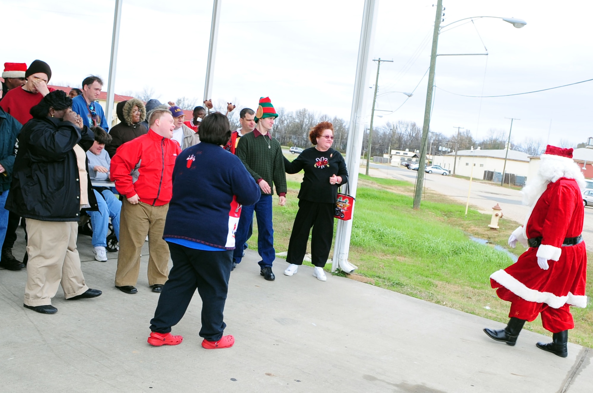 BARKSDALE AIR FORCE BASE, La. – Santa disembarks a Barksdale fire engine and greets the clients of the Handicapped Are Producers House during their holiday party, Dec. 11.  HAP House is a non-profit organization that provides mentally and physically handicapped persons  the chance to socialize and work for a living in a safe environment. (U.S. Air Force photo by Senior Airman Joanna M. Kresge)