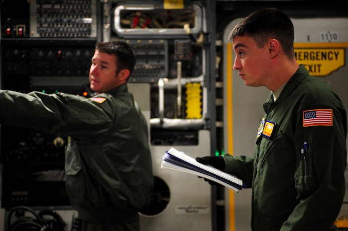 U.S. Air Force Staff Sgt. Thomas Elsworth (left), performs checklist tasks with Senior Airman Kenneth Common during there pre-flight duties as loadmasters with the 16th Airlift Squadron, Charleston Air Force Base, S.C. The Airmen crewed a C-17 aircraft from Charleston AFB during a strategic brigade airdrop exercise over North Auxiliary Airfield near North, S.C., Dec. 16, 2009, demonstrating the global projection of U.S. airpower. Airborne Soldiers from the 2-319th Airborne Field Artillery, 82nd Airborne Division, Ft. Bragg, N.C., were air dropped in the exercise along with cargo pallets to simulate the seizure of a remote airfield, providing a joint training opportunity for the Airmen and Soldiers. The training mission included airdrops over North Auxiliary Airfield, aerial refueling training and simulated aero medical evacuation.  (U.S. Air Force photo/Staff Sgt. Joshua L. DeMotts) (Released)