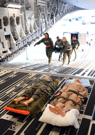 Airmen with the 315th Aeromedical Evacuation Squadron load medical equipment on a Charleston Air Force Base C-17 prior to taking off for a training mission from Charleston AFB, S.C. Dec. 16, 2009. The base conducted a large formation exercise utilizing 10 C-17 aircraft. The training mission included airdrops over North Auxiliary Airfield, aerial refueling training and simulated aeromedical evacuations. (U.S. Air Force photo/Master Sgt. Shane Cuomo)(Released)