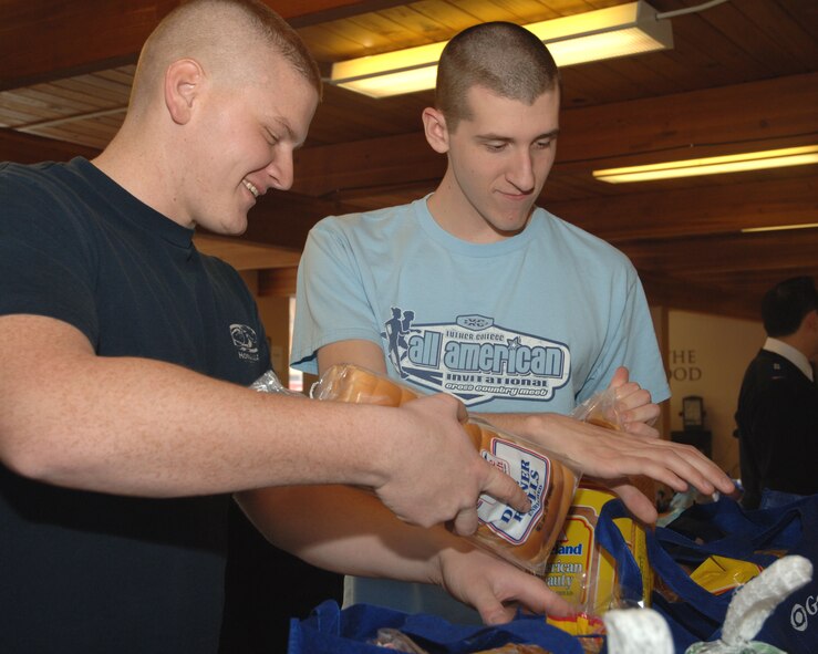 Two Airmen from Grand Forks Air Force Base fill boxes with food Dec. 17 at a local Salvation Army.  More than 25 Airmen spent Dec. 11 through Dec. 18 helping the local Salvation Army prepare toy bags and food boxes for 420 families in Grand Forks County and the city of East Grand Forks. (U.S. Air Force photo by Senior Airman R. Michael Longoria)
