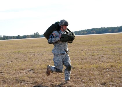 Staff Sgt. Robert Bylek runs to the rally point to meet with other Soldiers from the 2-319th Airborne Field Artillery, 82nd Airborne Division, Ft. Bragg, N.C., during a strategic brigade airdrop exercise over North Auxiliary Airfield near Northern, S.C., Dec. 16. 2009. The Soldiers were airdropped in the exercise along with cargo pallets to simulate the seizure of a remote airfield, providing a joint training opportunity for the Airmen and Soldiers. The training mission included cargo airdrops over North Auxiliary Airfield, aerial refueling training and simulated aeromedical evacuation. (U.S. Air Force photo/Senior Airman Katie Gieratz)(Released)
