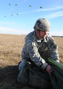 Staff Sgt. Daniel Freeman prepares to pack up his shoot after being airdropped during a strategic brigade airdrop exercise over North Auxiliary Airfield near Northern, S.C., Dec. 16, 2009. The Soldiers were airdropped along with cargo pallets to simulate the seizure of a remote airfield, providing a join training opportunity for the Airmen and Soldiers. The training mission also included cargo airdrops over North Auxiliary Airfield, aerial refueling training and simulated aeromedical evacuation. Freeman is with the 82.d Airborne Division, Ft. Bragg, N.C. (U.S. Air Force photo/Senior Airman Katie Gieratz)(Released)
