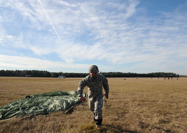 Staff Sgt. Daniel Freeman prepares to pack up his shoot after being airdropped during a strategic brigade airdrop exercise over North Auxiliary Airfield near Northern, S.C., Dec. 16, 2009. The Soldiers were airdropped along with cargo pallets to simulate the seizure of a remote airfield, providing a join training opportunity for the Airmen and Soldiers. The training mission also included cargo airdrops over North Auxiliary Airfield, aerial refueling training and simulated aeromedical evacuation. Freeman is with the 82.d Airborne Division, Ft. Bragg, N.C. (U.S. Air Force photo/Senior Airman Katie Gieratz)(Released)