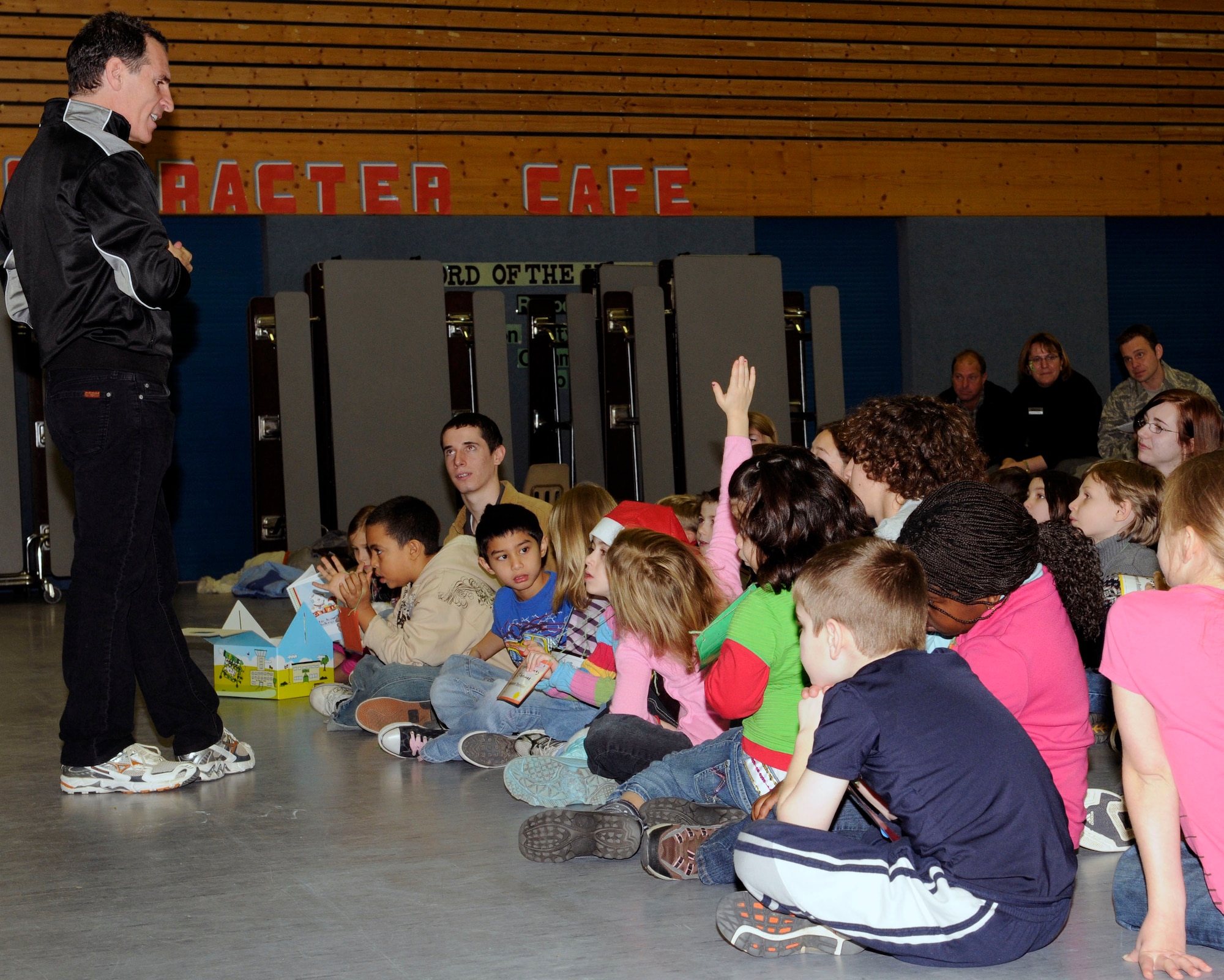 Mr. Trevor Romain, children's author and motivational speaker, answers questions from youth at Ramstein Elementary School, Ramstein Air Base, Germany, Dec. 17, 2009. Mr. Romain is the creator of the Air Force Family focused campaign, "Cuzzie the Bear” designed to comfort school-age children while their parents are deployed. (U.S. Air Force photo by Airman 1st Class Brea Miller)