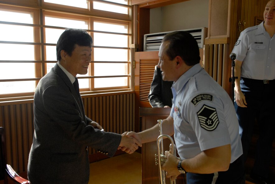 Master Sgt. Sam Cliff of the Alaska Brass Band from Elmendorf Air Force Base, Alaska, shakes hands with the principal of Jangdang Elementary School after a performance there Dec. 16. The Alaska Brass visited Osan Air Base and its surrounding areas Dec. 14-19. (U.S. Air Force photo by Staff Sgt. Terri Barriere)