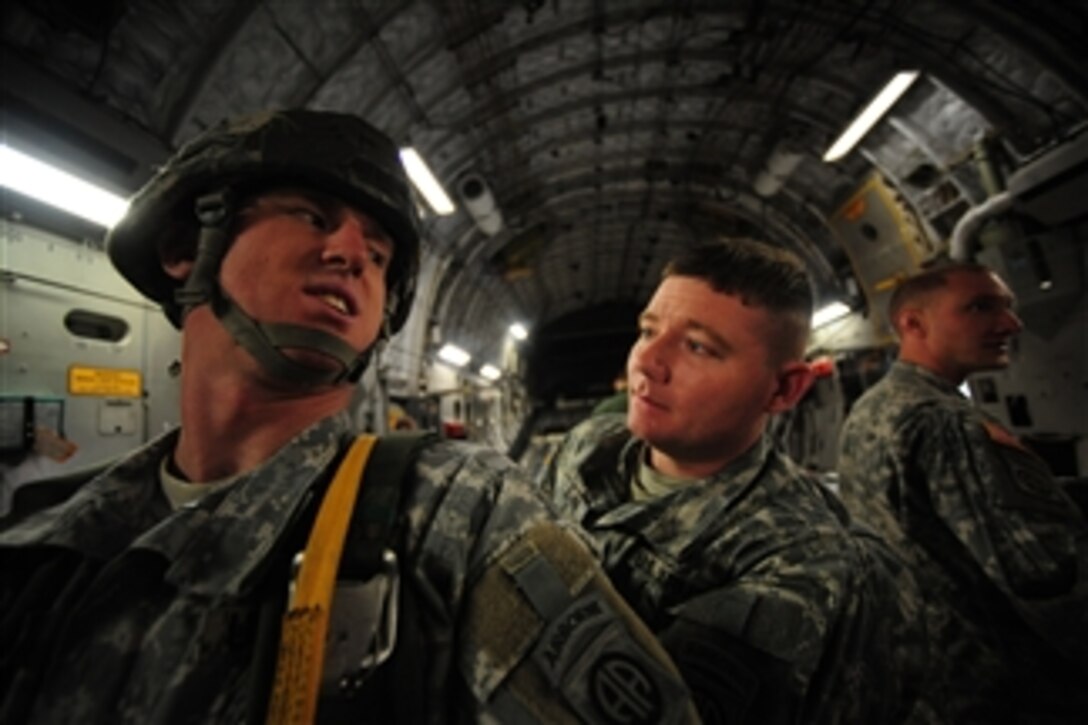 U.S. Army Sgt. Anthony Gann (right) with 2nd Battalion, 325th Airborne Infantry Regiment, 82nd Airborne Division, Fort Bragg, N.C., inspects Sgt. Thomas Hutton's parachute aboard a C-17 Globemaster III aircraft from Charleston Air Force Base, S.C., prior to a strategic brigade airdrop exercise over North Auxiliary Airfield, S.C., on Dec. 16, 2009.  Hutton is assigned to 1st Battalion, 73rd Cavalry Regiment, 82nd Airborne Division.  U.S. soldiers and cargo pallets were airdropped during the exercise to simulate the seizure of a remote airfield, providing a joint training opportunity for airmen and soldiers.  The training mission included airdrops over North Auxiliary Airfield, aerial refueling and simulated aeromedical evacuation.  