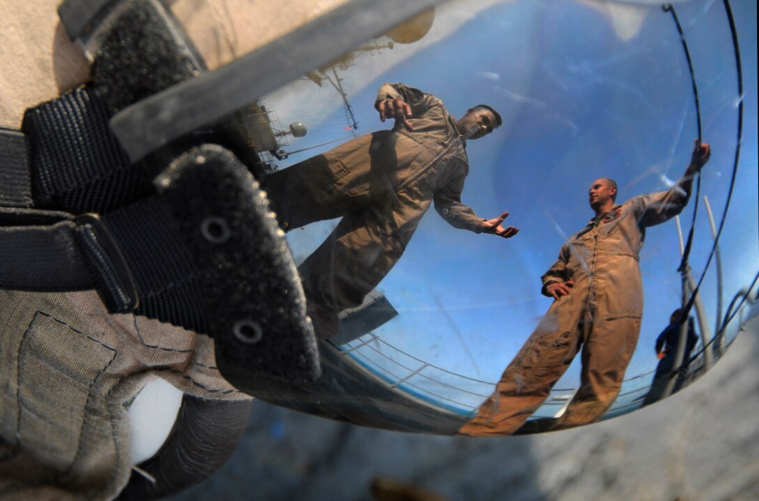 Before taking a familiarization flight in the front seat of an AH-1W Super Cobra, Col. Andrew Wilcox, left, talks to attack-helicopter pilot Capt. Gregory Sorelle aboard USS Cleveland Dec. 18. Wilcox is the commanding officer of Battalion Landing Team 2/4, aka the Magnificent Bastards, the ground-combat element of the 11th Marine Expeditionary Unit.