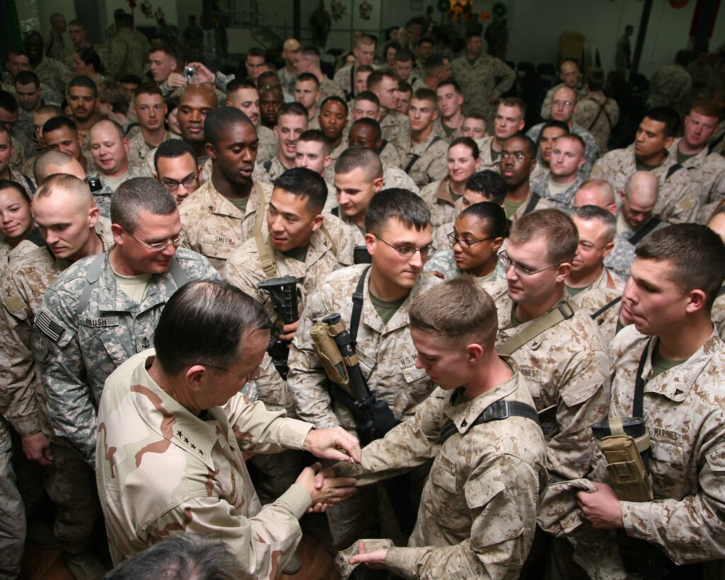 Adm. Mike Mullen, the chairman of the Joint Chiefs of Staff, hands out coins to service members at a town hall meeting aboard Al Asad Air Base, Iraq, Dec. 19, 2009. During the town hall, Mullen discussed change, leadership and the future of the U.S. armed forces.