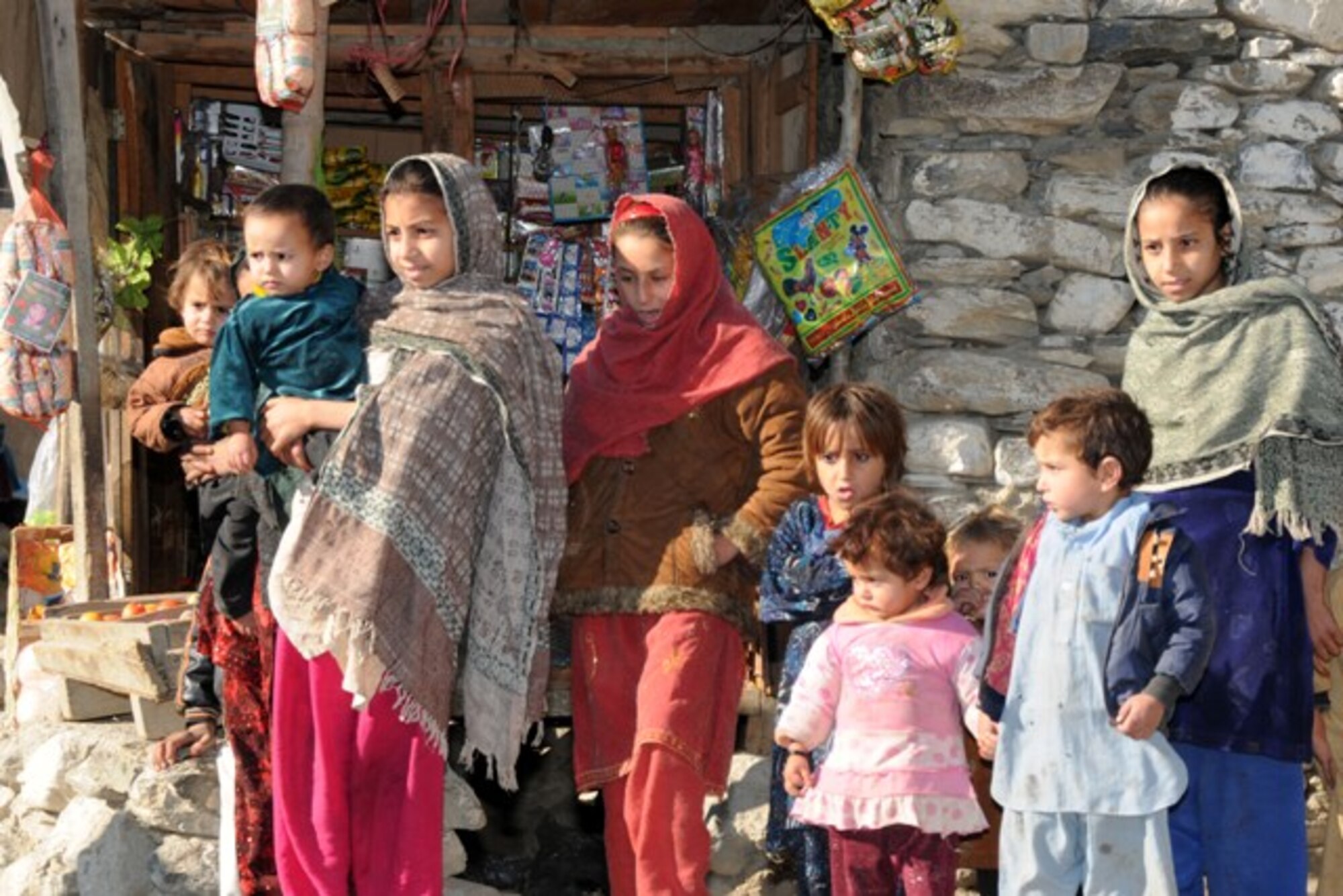 KUNAR PROVINCE, Afghanistan – Local Afghan children in downtown Asadabad watch a Provincial Reconstruction Team-Kunar patrol conduct a final quality assurance and quality check of a new 4-kilometer road through the provincial capital prior to a dedication ceremony, recently. The Provincial Reconstruction Team-Kunar engineers did the check to ensure the Kunar Construction Company did a good job building the road. The project took nearly one year and approximately $1 million to complete. The hope for the new road is it will continue to spur economic development and job growth in the city. More than 50 provincial leaders and tribal elders gathered at the ceremony site after the QA/QC check to do the ribbon cutting ceremony. (U.S. Air Force photo/Tech. Sgt. Brian Boisvert)