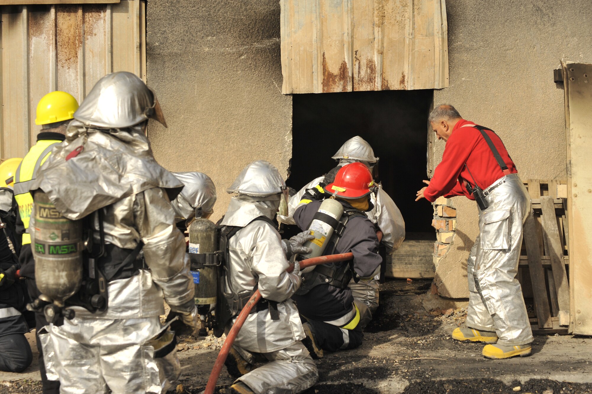 Iraqi firefighters stack by the door of a burning building during a training exercise north of Sather Dec. 16, 2009. The Iraqi fire fighters, who have been trained by Air Force fire fighters, demonstrated thier capabilities to Major Gen. James Hunt, Multi-National Corps- Iraq deputy commander. (U.S. Air Force photo/Senior Airman Eric Summers Jr./ released)
