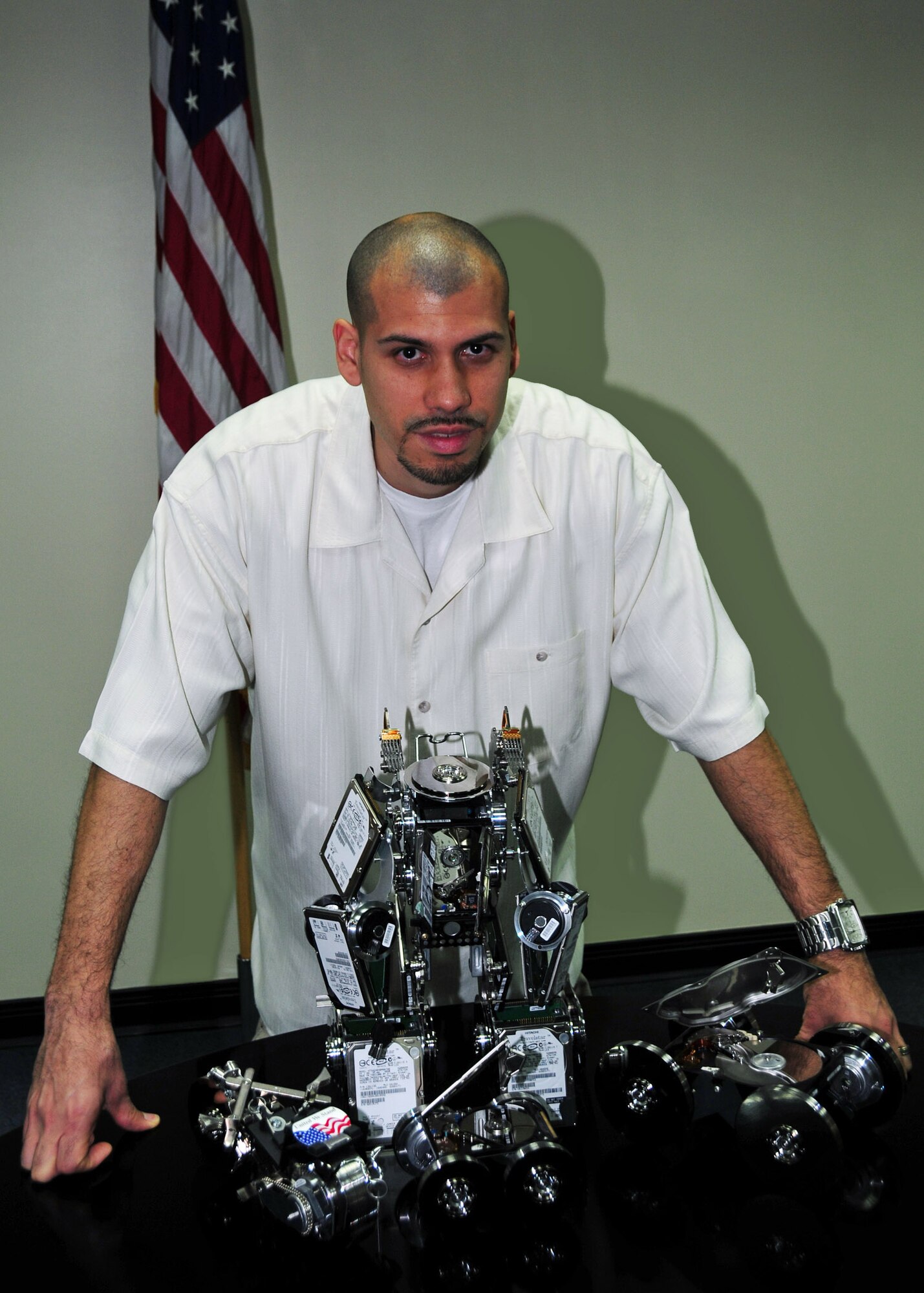 SOUTHWEST ASIA -- Miguel Rivera, 386th Expeditionary Communications Squadron system administrator, stands by sculptures he built from old hard drives and computer parts at an airbase in Southwest Asia Dec. 19, 2009.  Mr. Rivera hails from Naples, Fla.  (U.S. Air Force photo/Tech. Sgt. Tony Tolley)