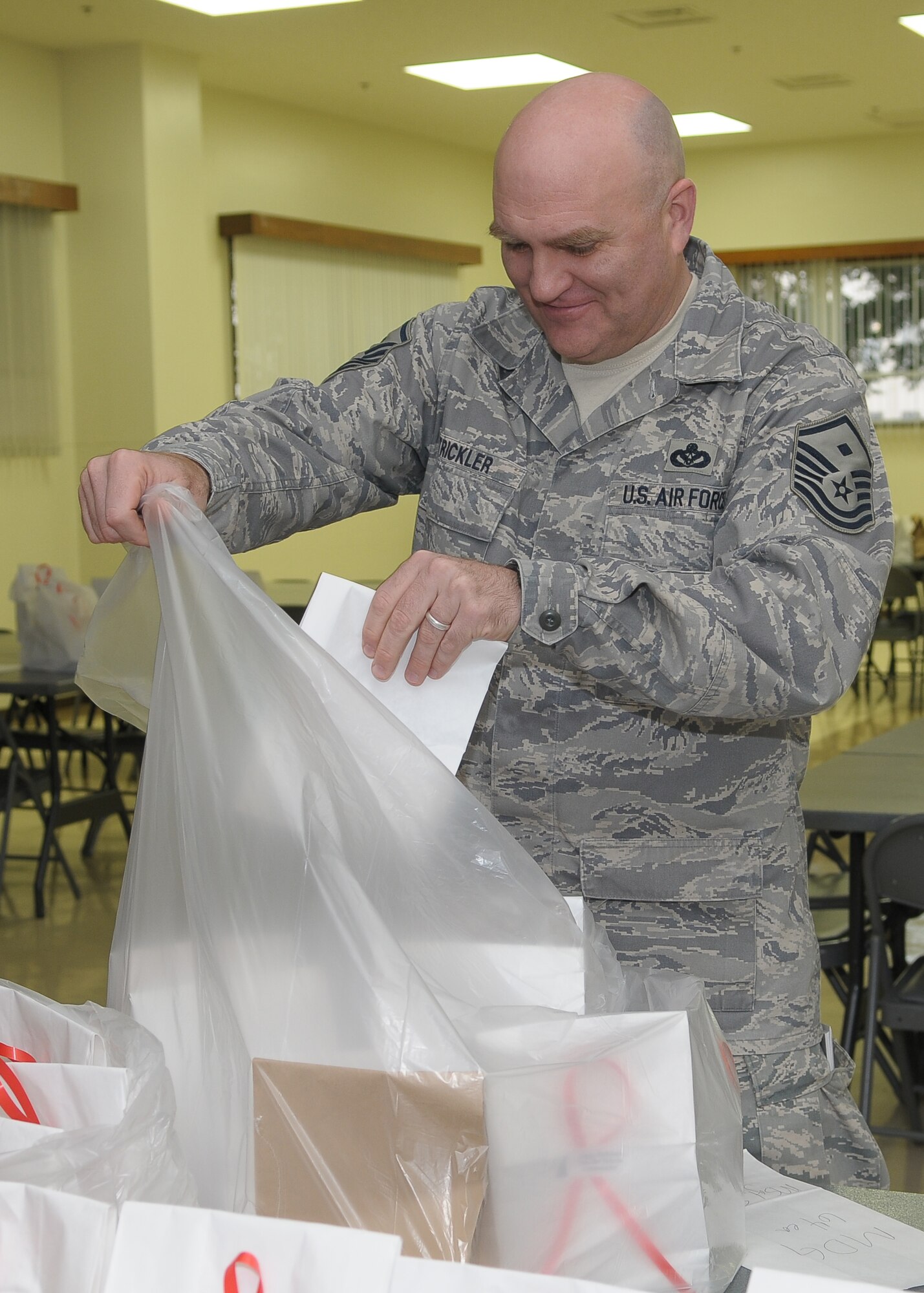 YOKOTA AIR BASE, Japan -- Master Sgt. Michael Strickler, 374th Medical Group first sergeant, prepares to deliver gift bags to his Airmen Dec. 18 during the Cookie Crunch event. More than 3,000 cookies were donated, bagged and distributed to Airmen in the dormitories by the Yokota Enlisted Spouses Club. (U.S. Air Force photo/Airman 1st Class Sean Martin)